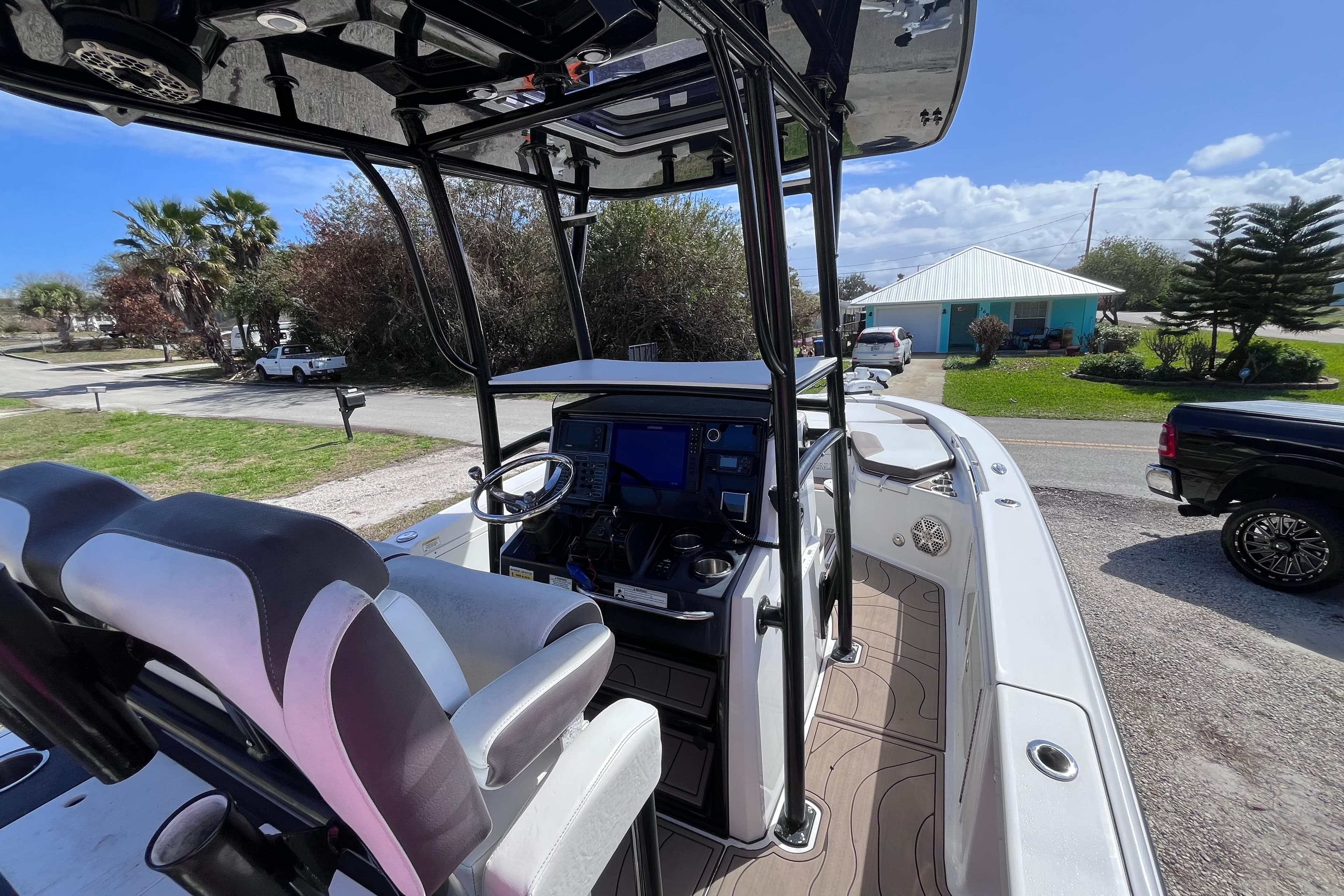 2016 Crevalle 26 Bay boat interior with steering console and seating, parked outdoors.