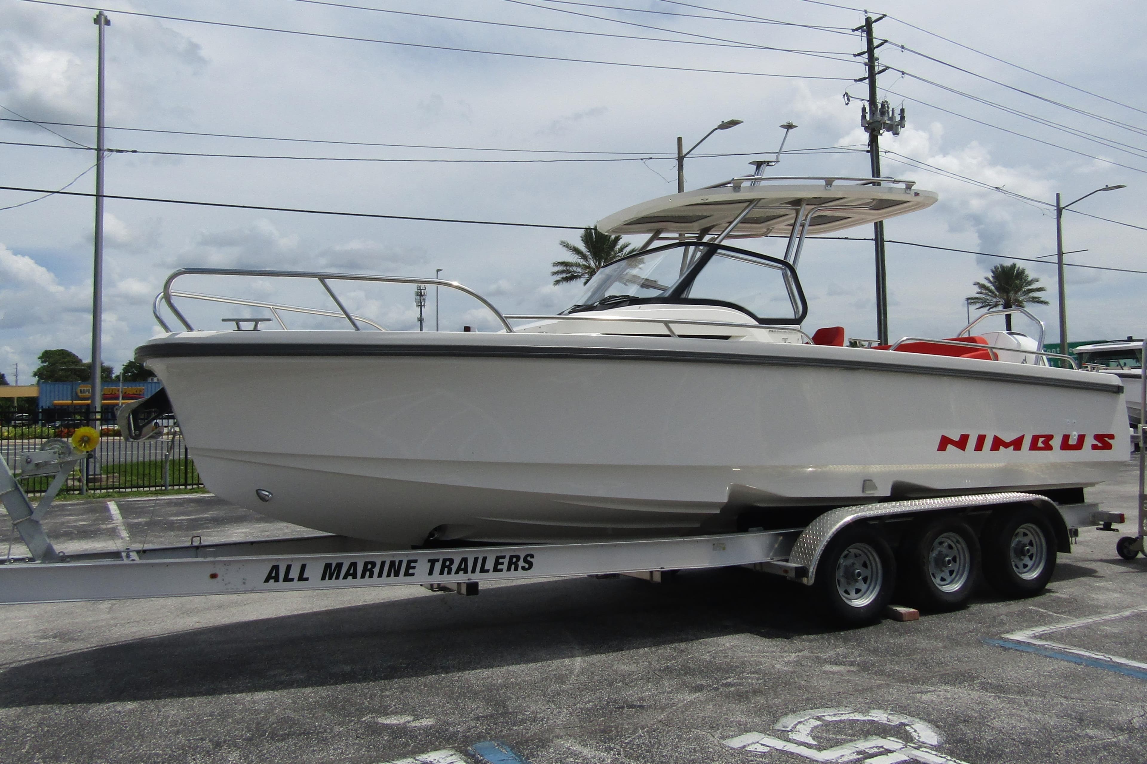 2024 Nimbus T8 boat on trailer in parking lot, side view.