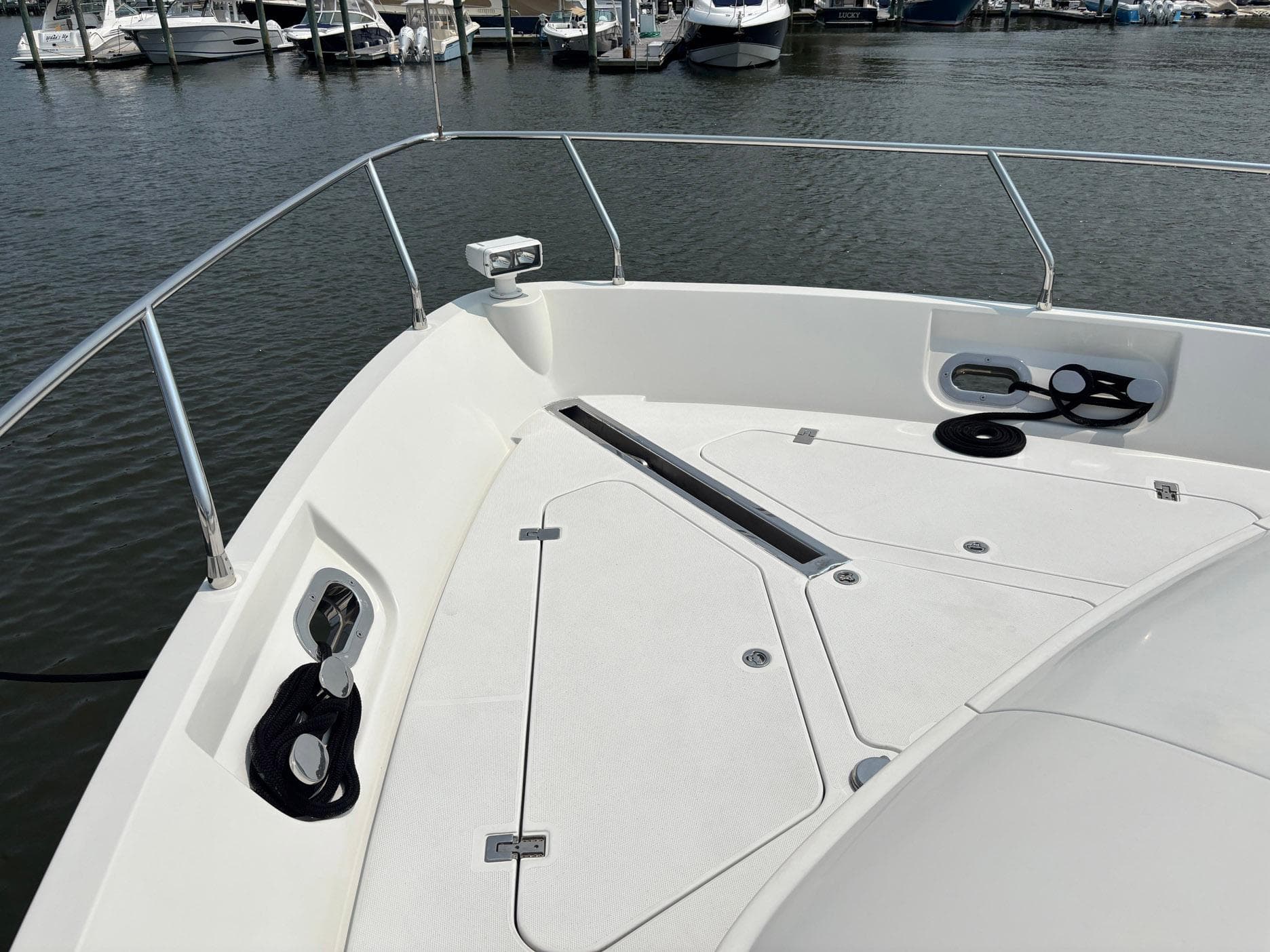 Bow of 2006 Marquis 65 yacht docked at marina, featuring sleek design and railing.