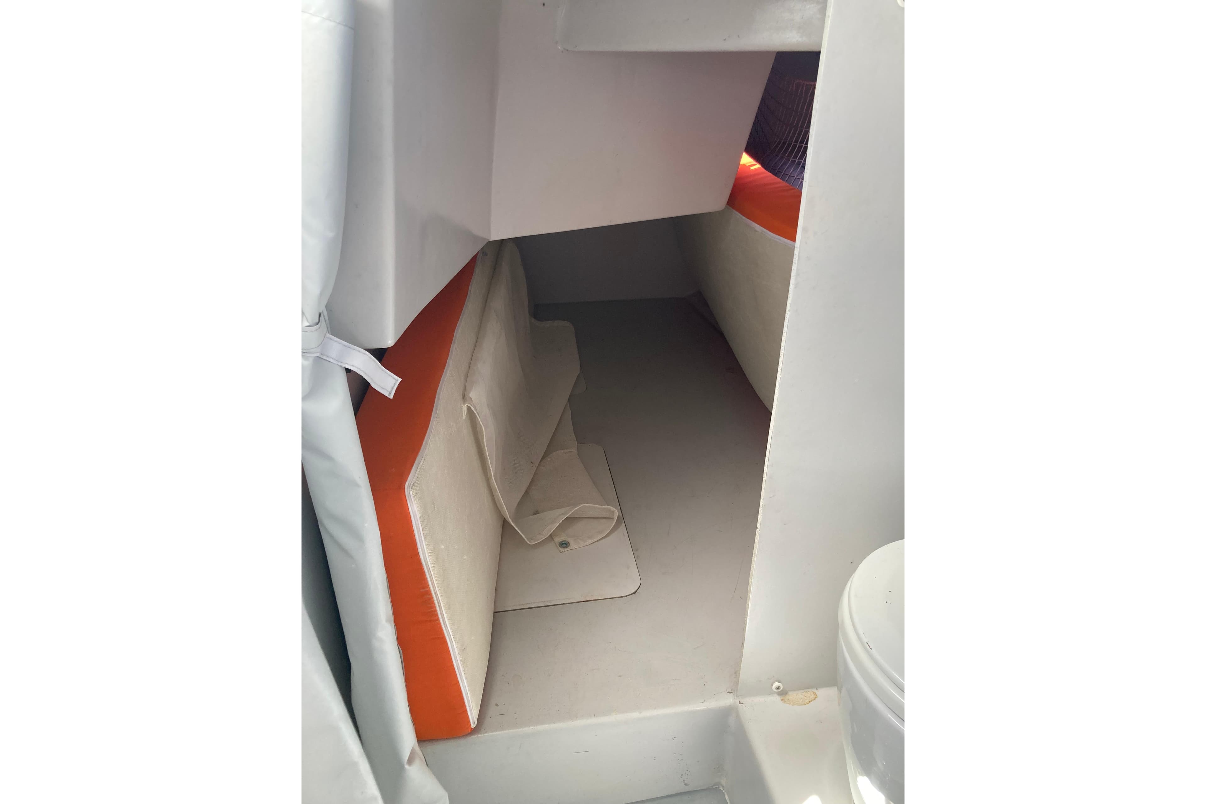 Interior cabin of 2014 Black Pepper CODE 1 boat with orange and white cushions.