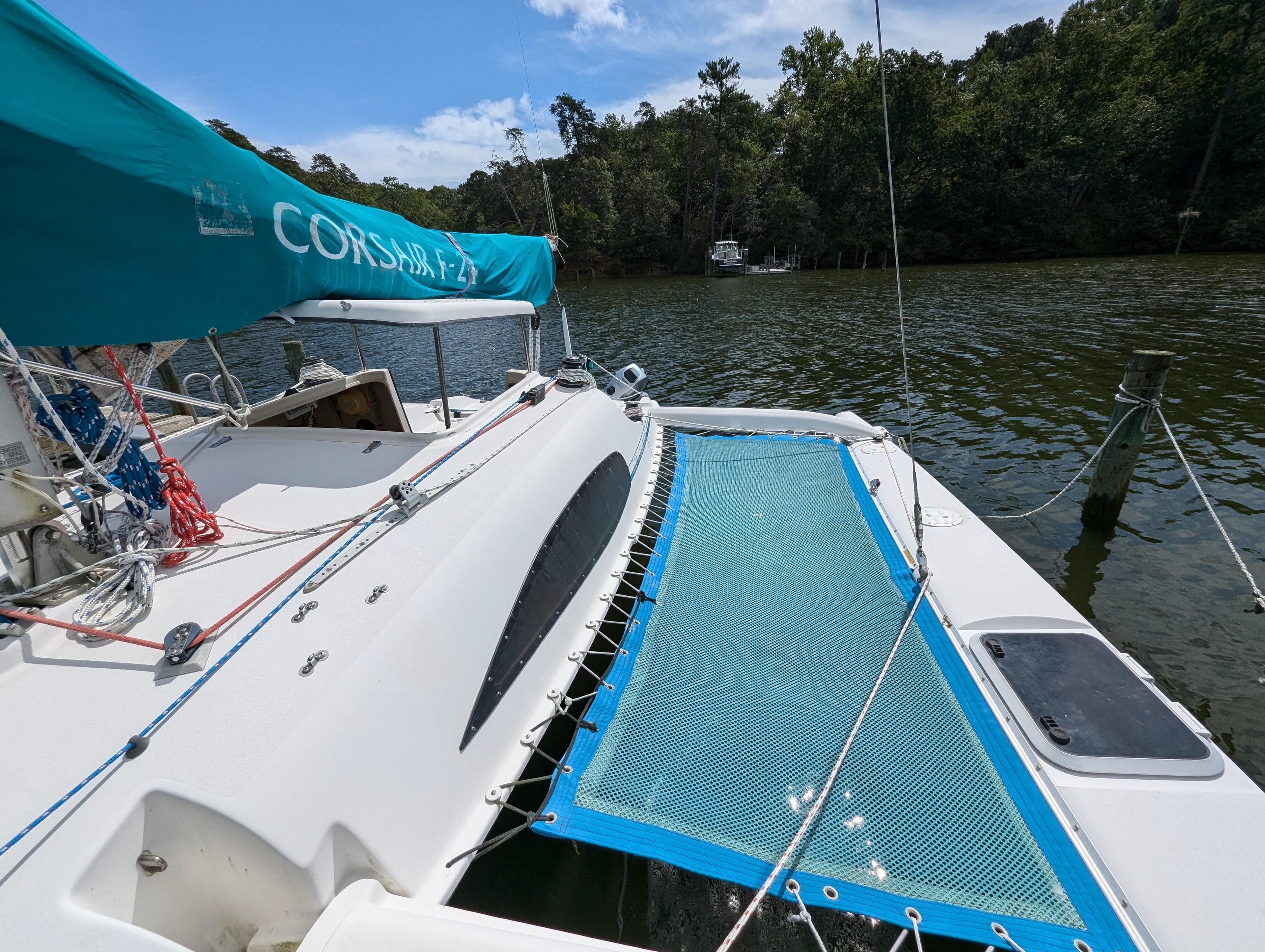 Corsair F-24 MkII trimaran sailboat docked on a calm river, 1999 model.