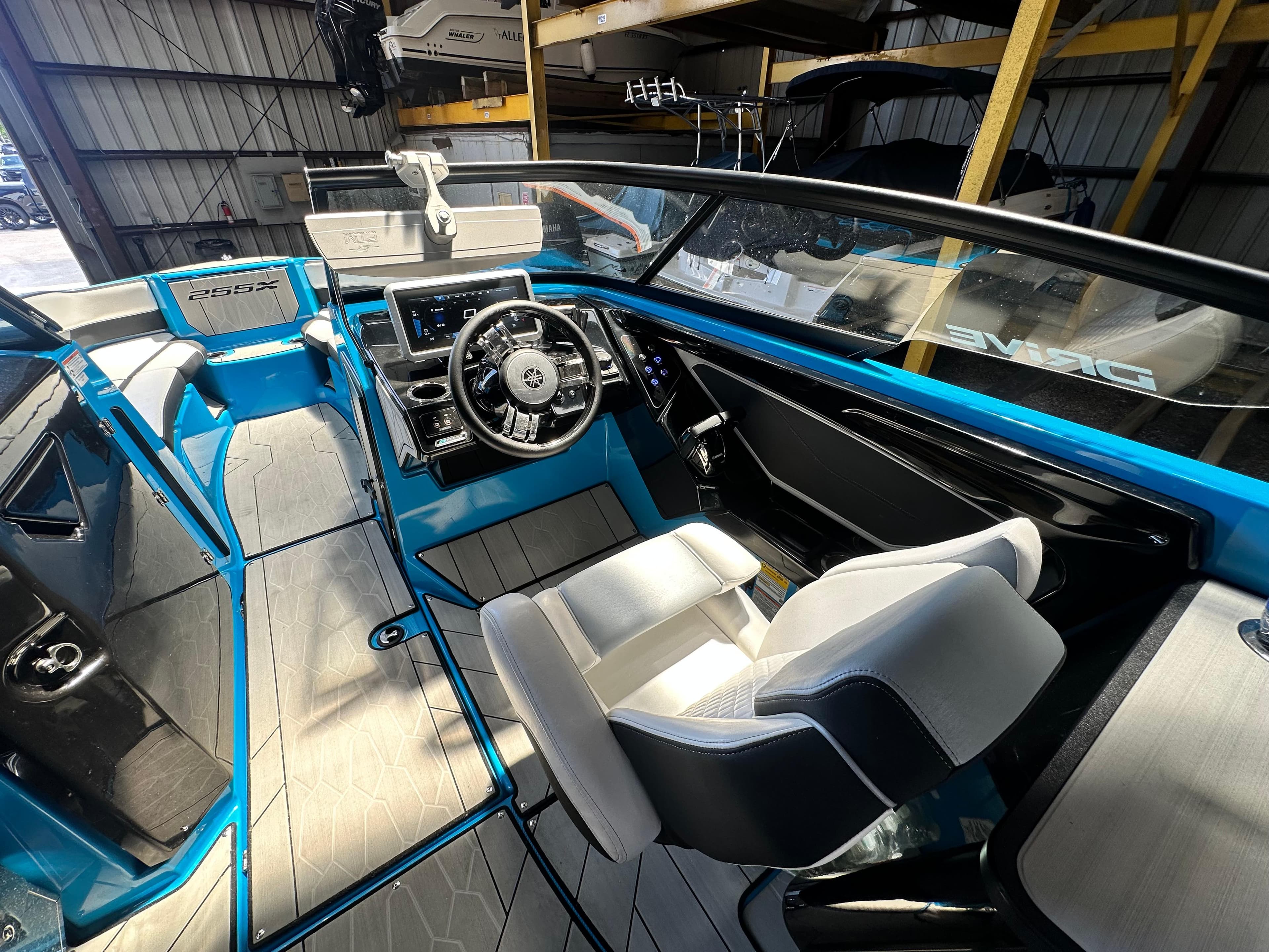 2023 Yamaha Boats 255XD interior with blue accents and modern dashboard.