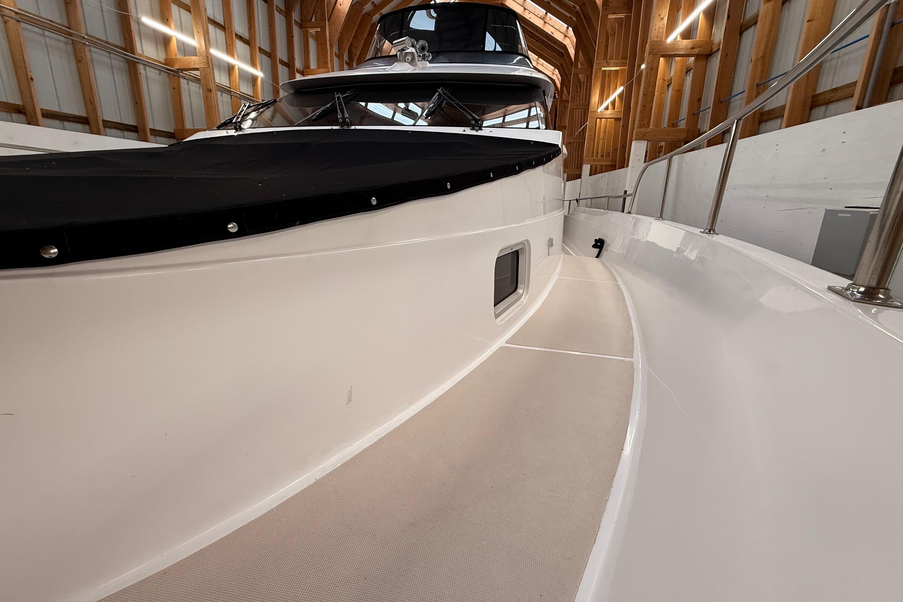 Northern Pacific 2000 Motor Yacht in wooden boathouse, showcasing sleek deck design.