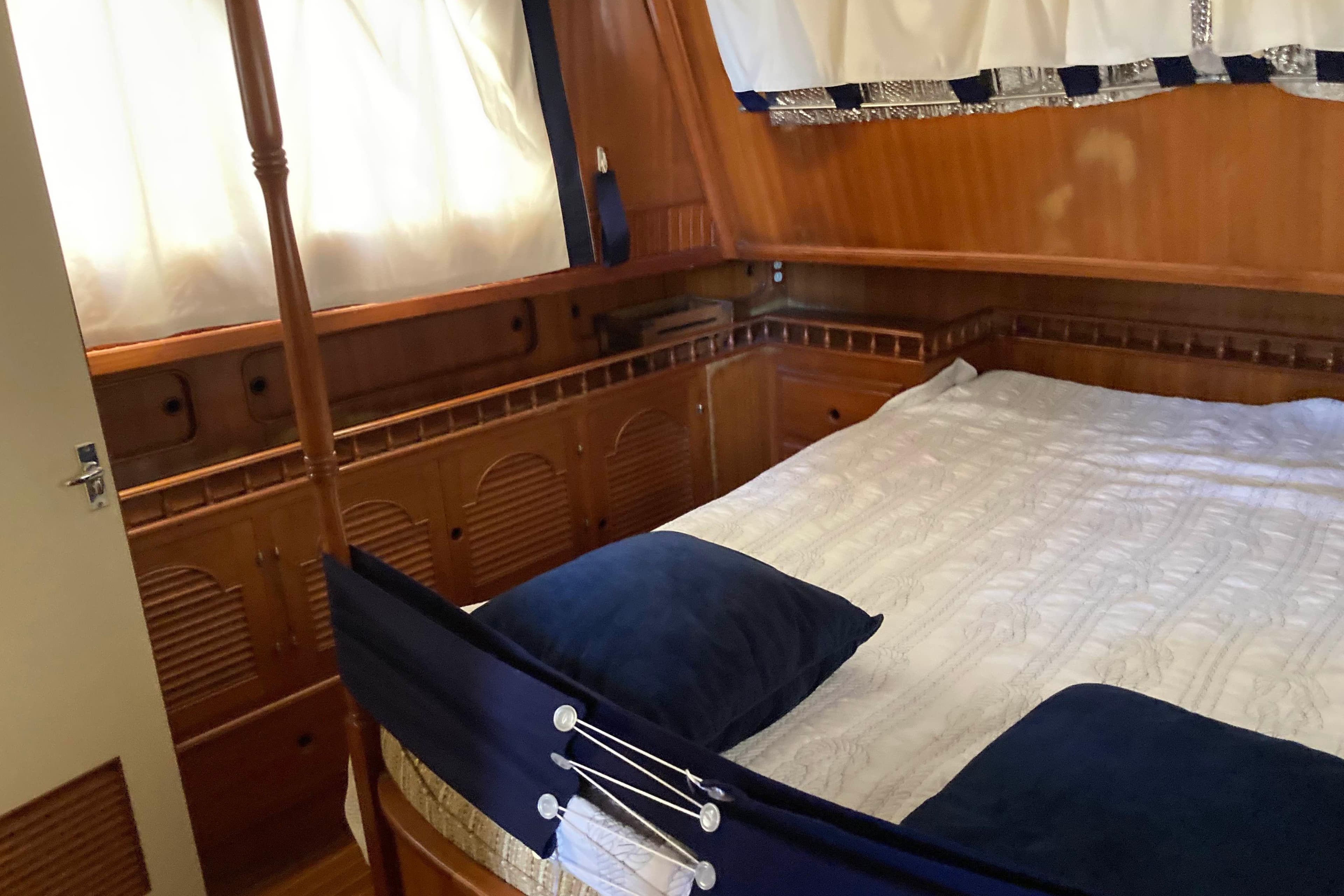 Cozy cabin interior of 1988 Albin 43 Trawler with wooden paneling and comfortable bedding.