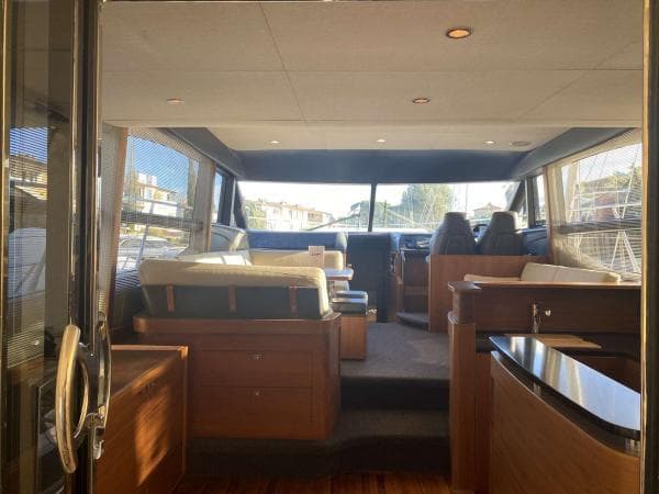 Interior of 2013 Princess 52 Flybridge yacht, featuring elegant wood finishes and spacious seating.