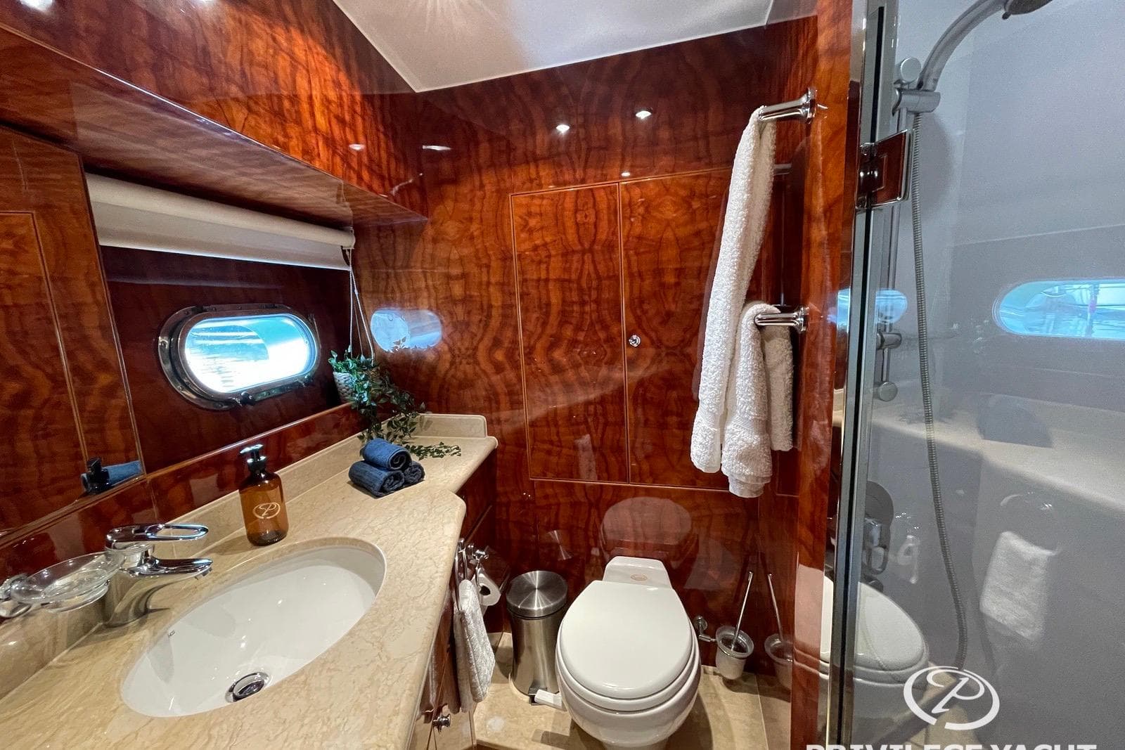 Luxurious bathroom in 2006 Monte Fino 76 yacht with elegant wood paneling and modern fixtures.