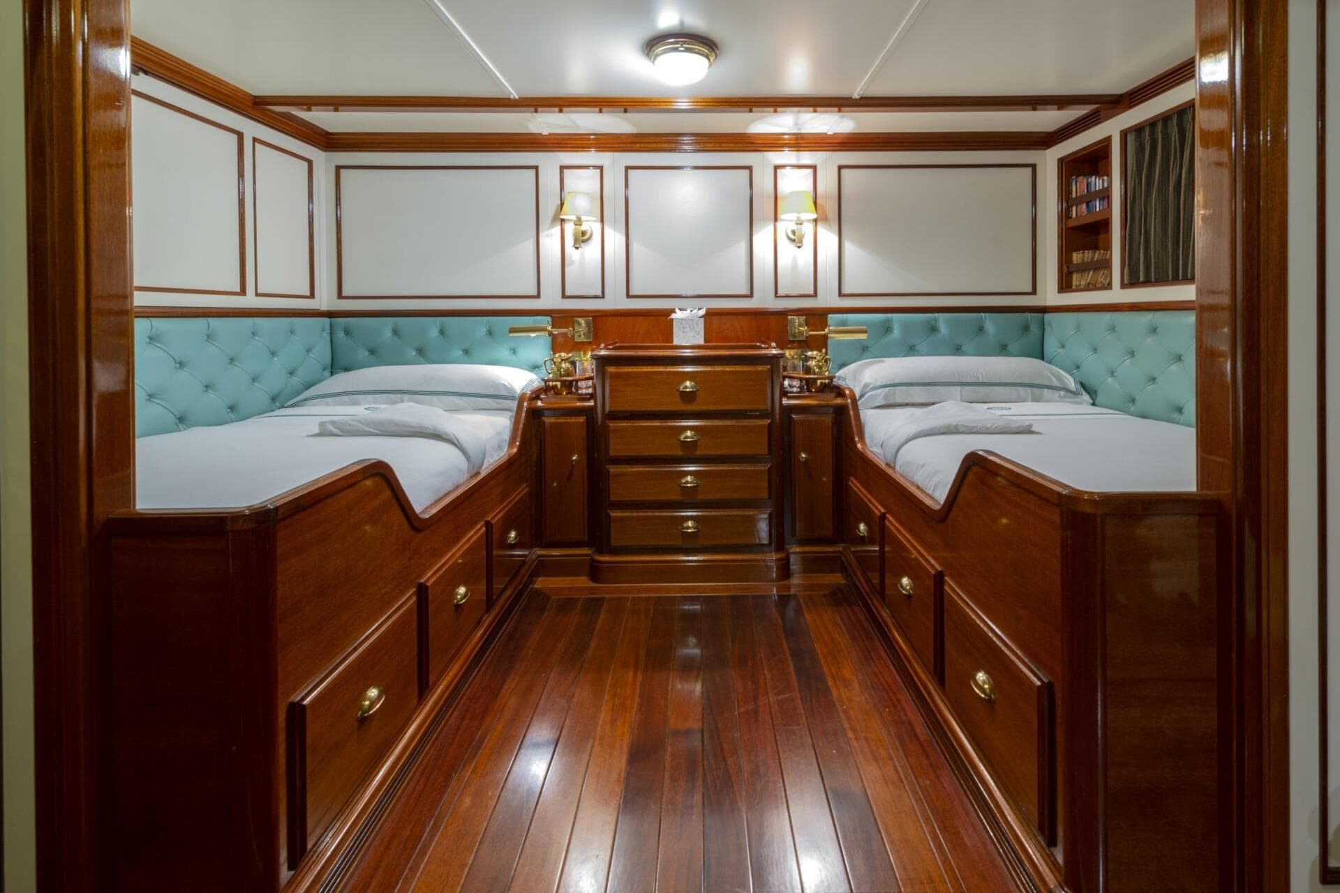 Luxurious twin cabin with wooden furnishings on a 2009 Pendennis 55 yacht.