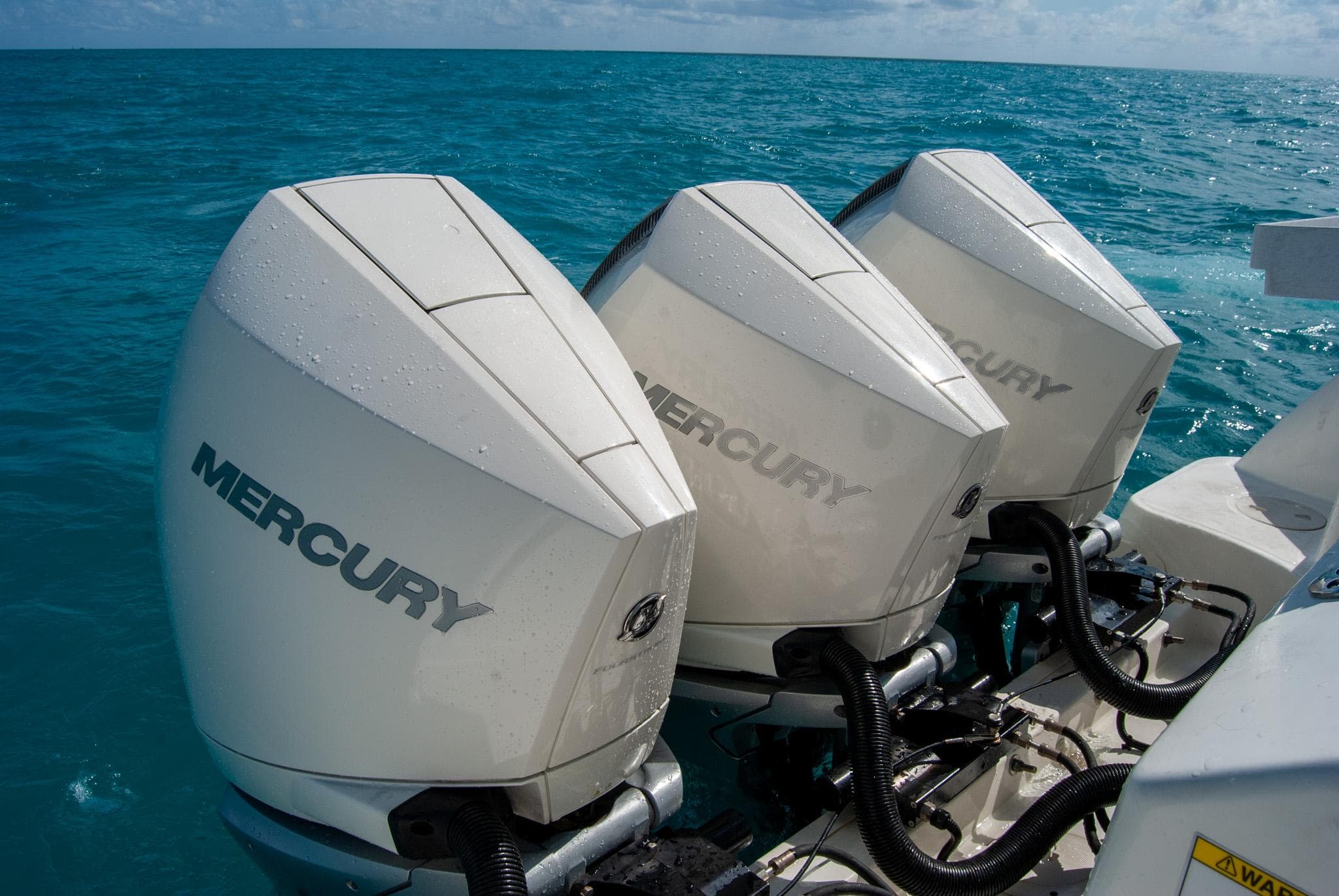 Triple Mercury outboard engines on a 2021 Boston Whaler 345 Conquest in blue ocean.