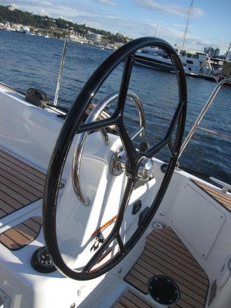 Steering wheel of a 2024 Jeanneau 380 sailboat on a sunny day.