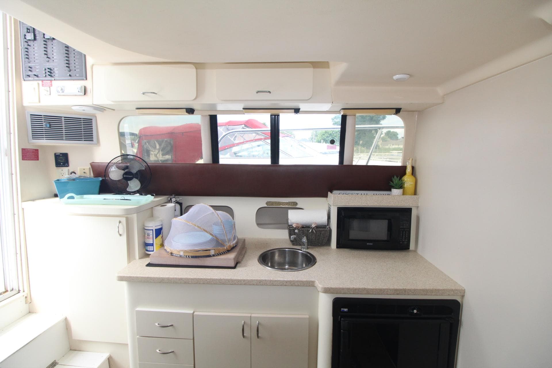 1999 Mainship 31 Sedan Bridge interior kitchen with sink, microwave, and storage cabinets.