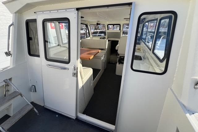 Interior view of a 2015 Stanley 30 Custom boat, featuring seating and a table.