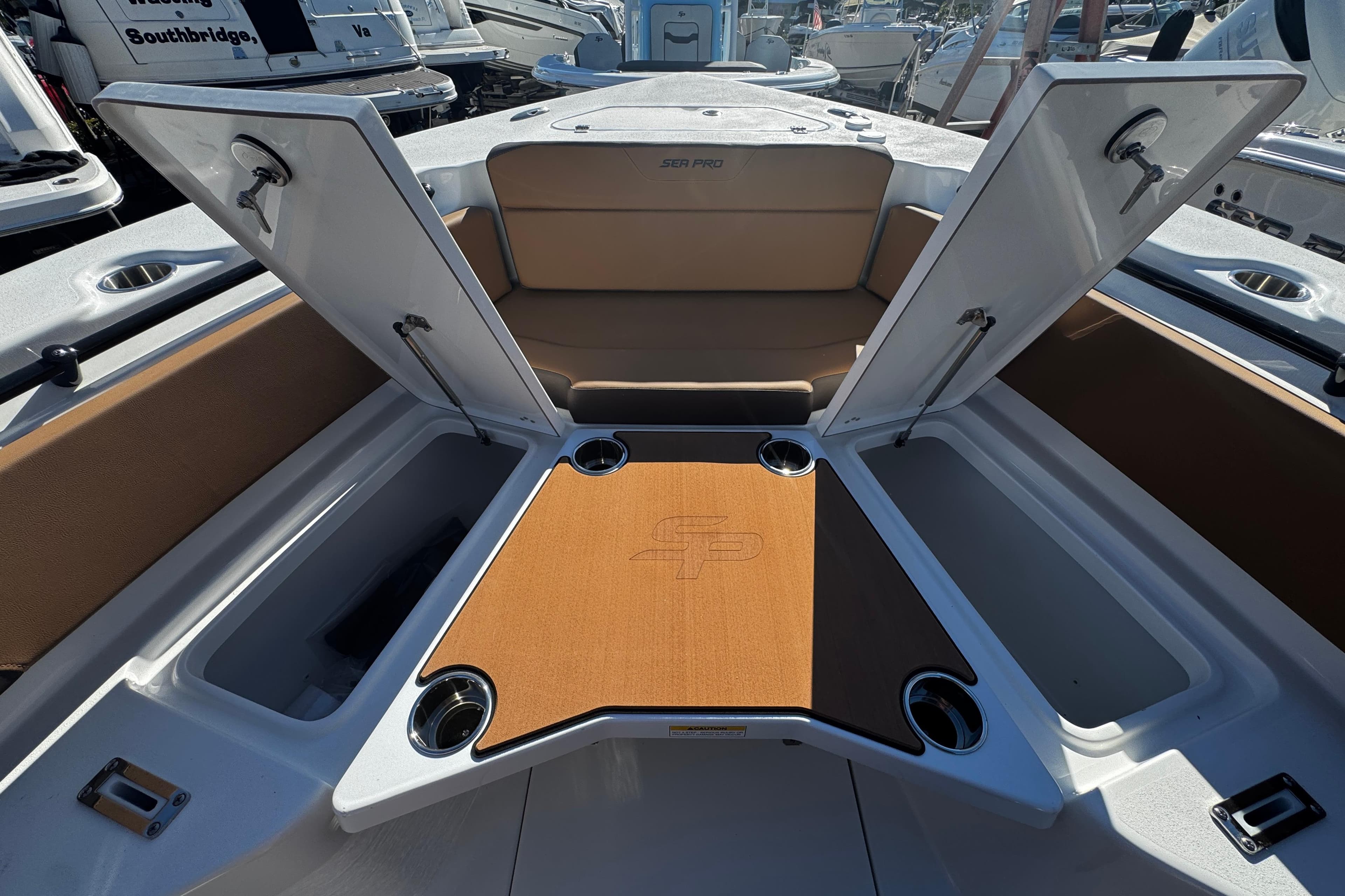 2026 Sea Pro 245FLX Sandbar boat interior with open storage compartments and cup holders.