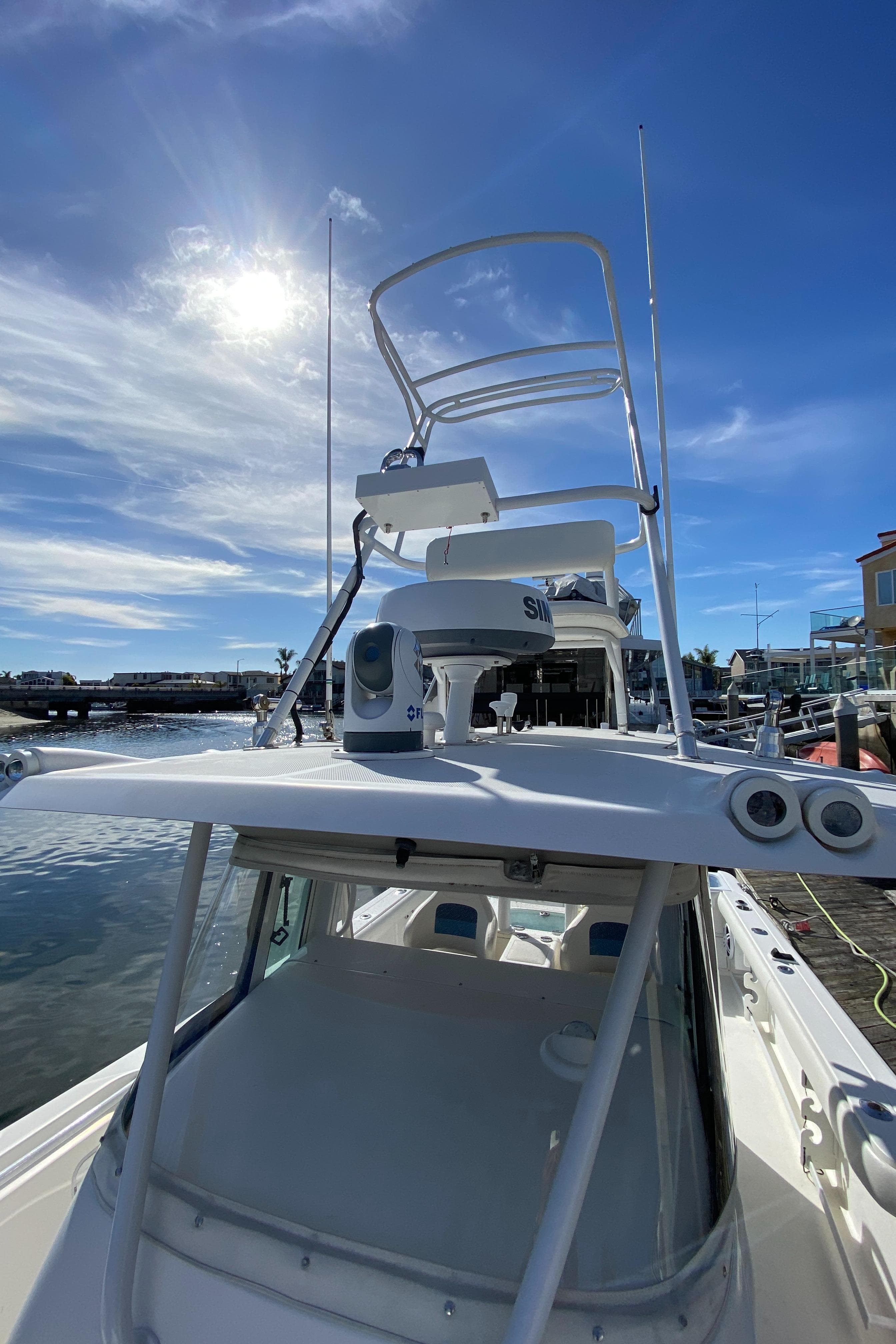 2008 Everglades 355 Center Console boat docked under a clear blue sky.