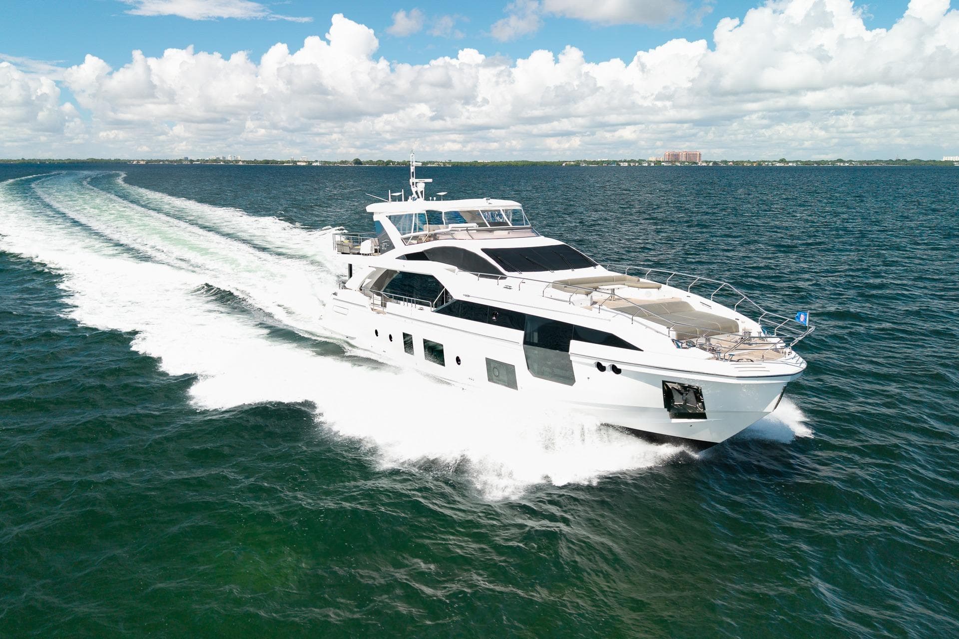 Luxurious 2022 Azimut Grande 27 METRI yacht cruising on open sea under blue sky.