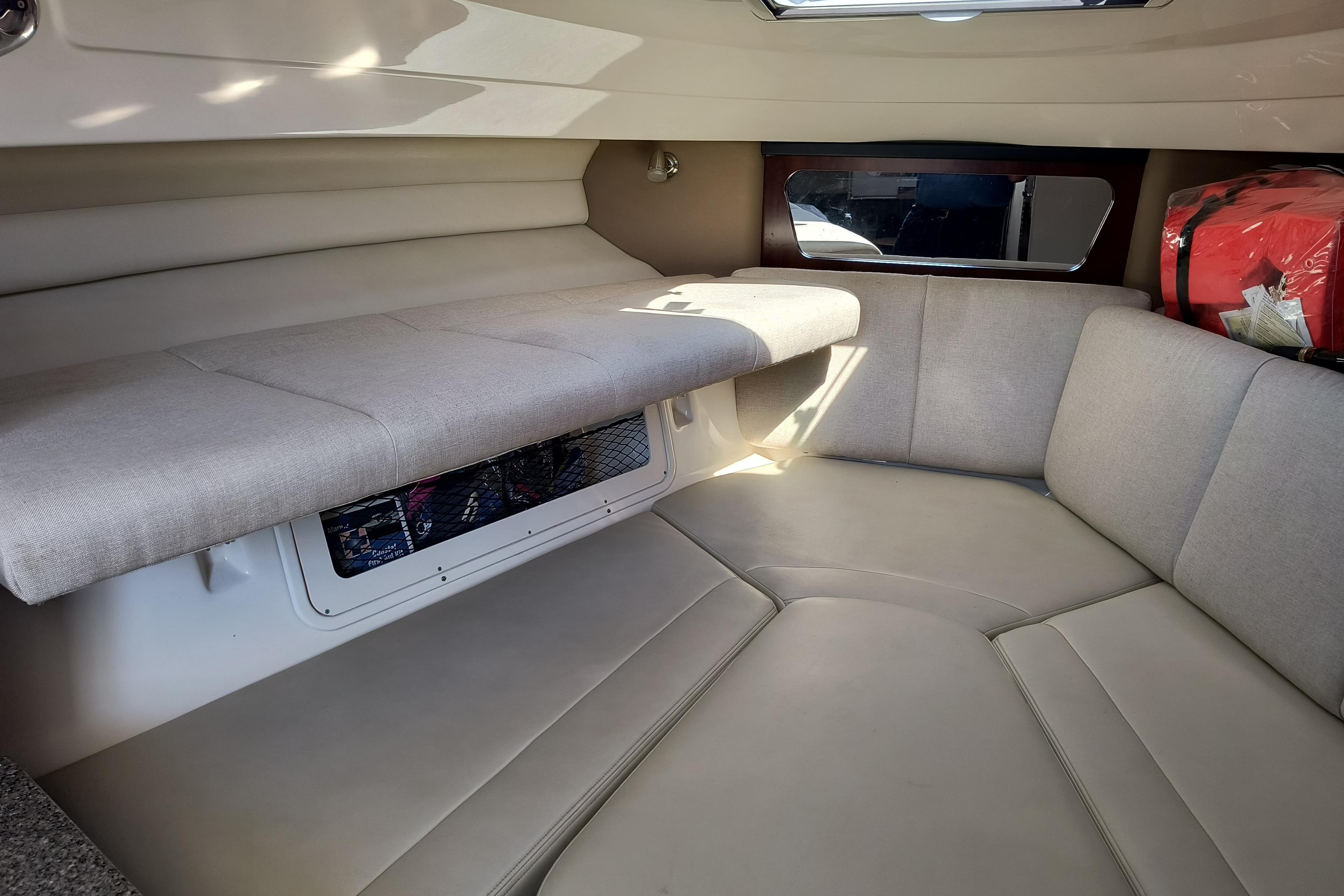 Interior cabin of 2015 Robalo R305 Walkaround boat, featuring cushioned seating and storage.