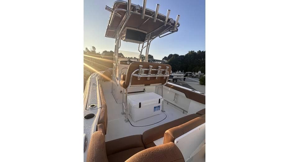 2025 Pioneer 202 Islander boat interior with seating and console at sunset.