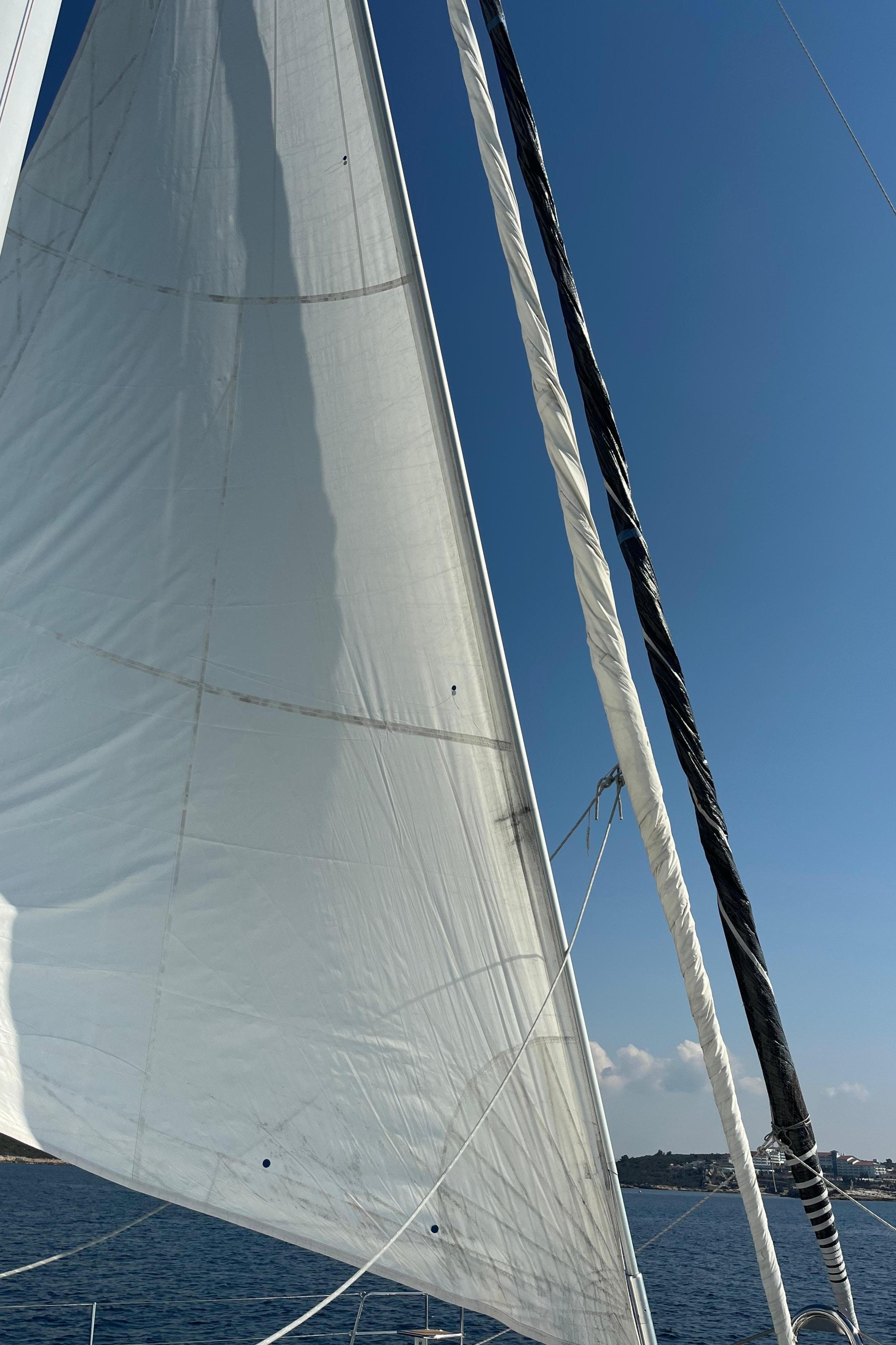 Sailing yacht Lagoon 620 Essence 2017 with white sails against blue sky.