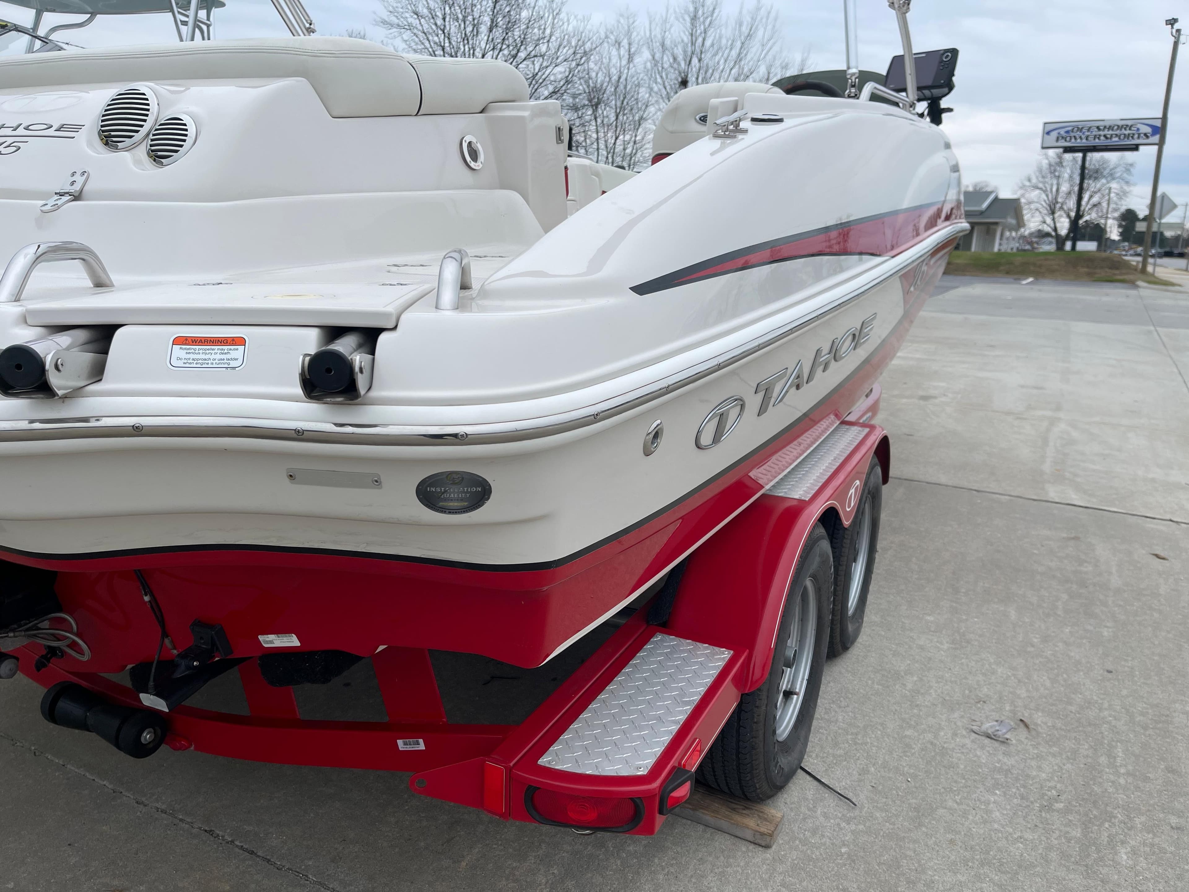 2016 Tahoe 215 Xi boat parked on red trailer.