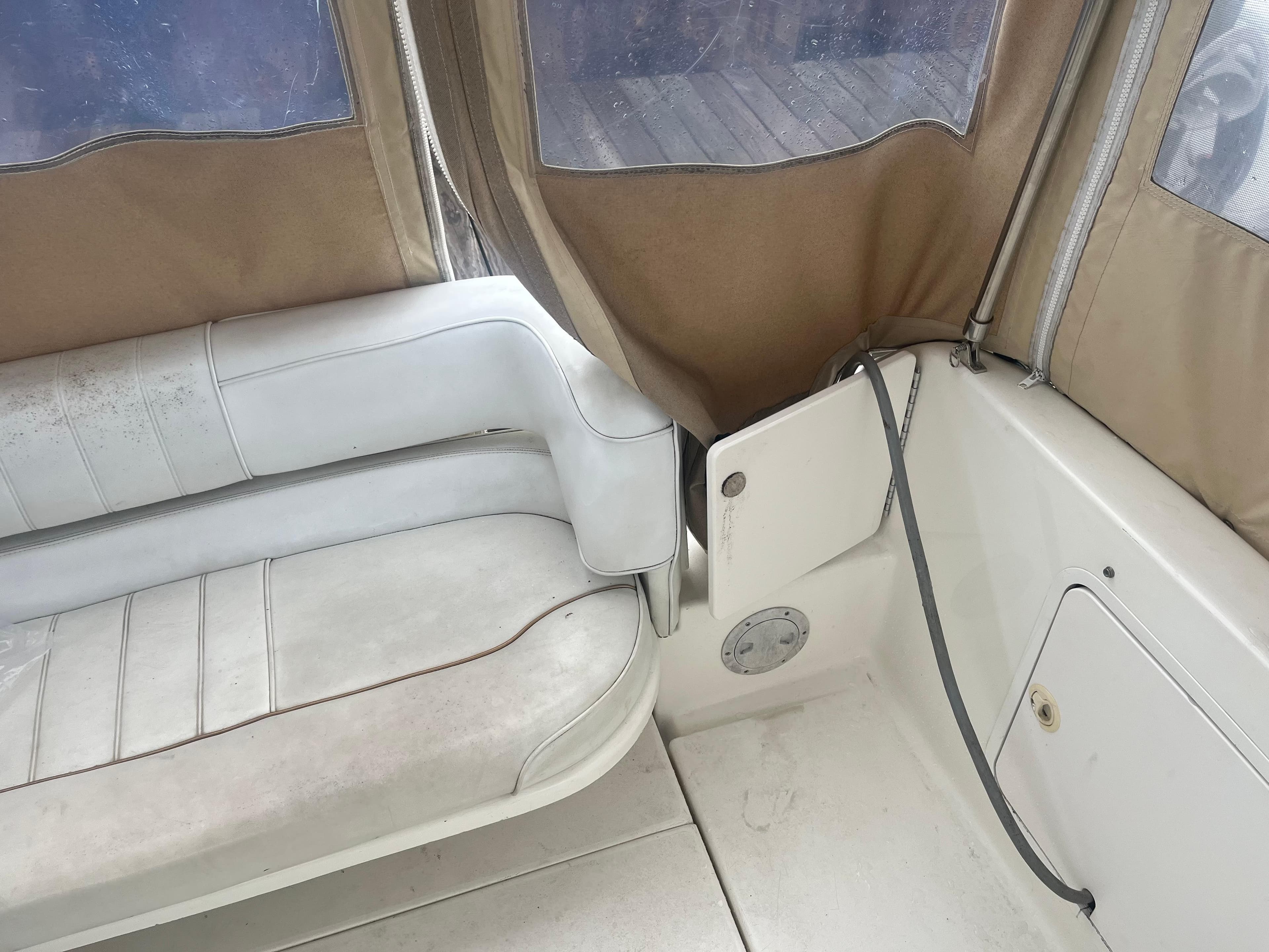 Interior of 1995 Sea Ray 250 Sundancer boat with white seating and tan canvas.