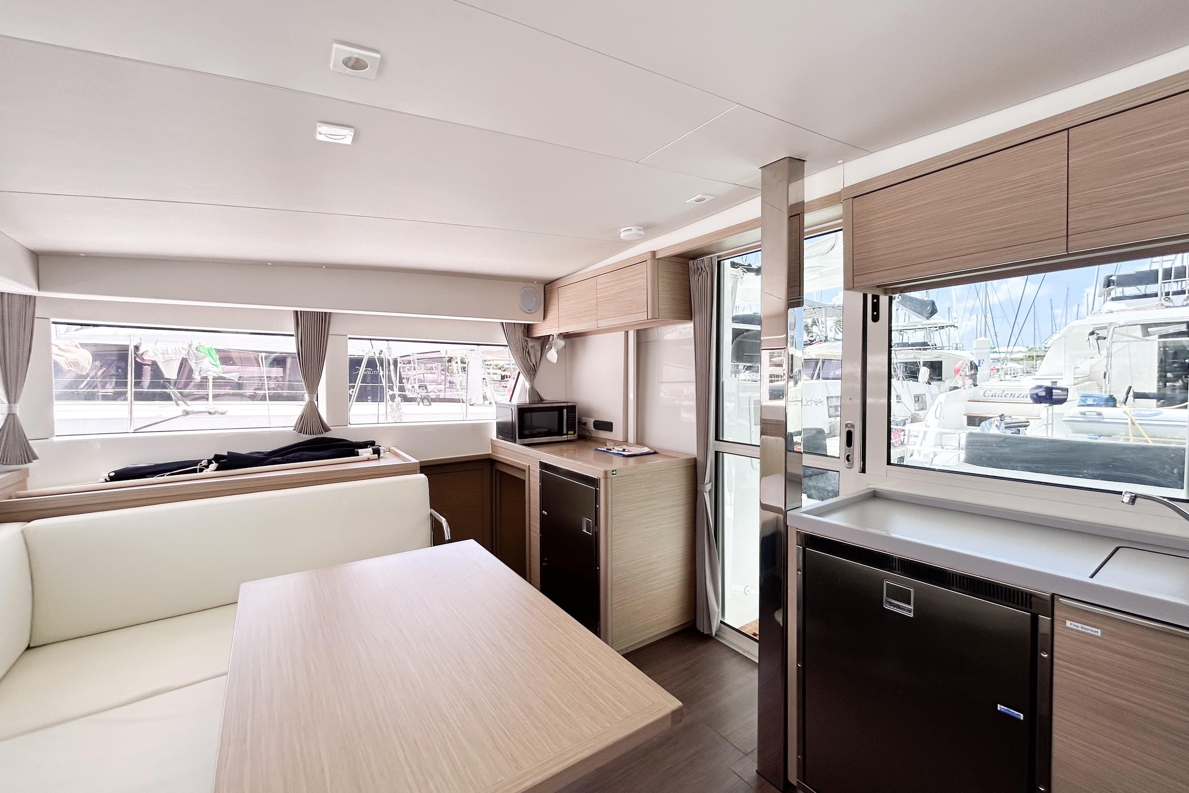 Modern interior of 2025 Lagoon 40 catamaran with sleek kitchen and dining area.