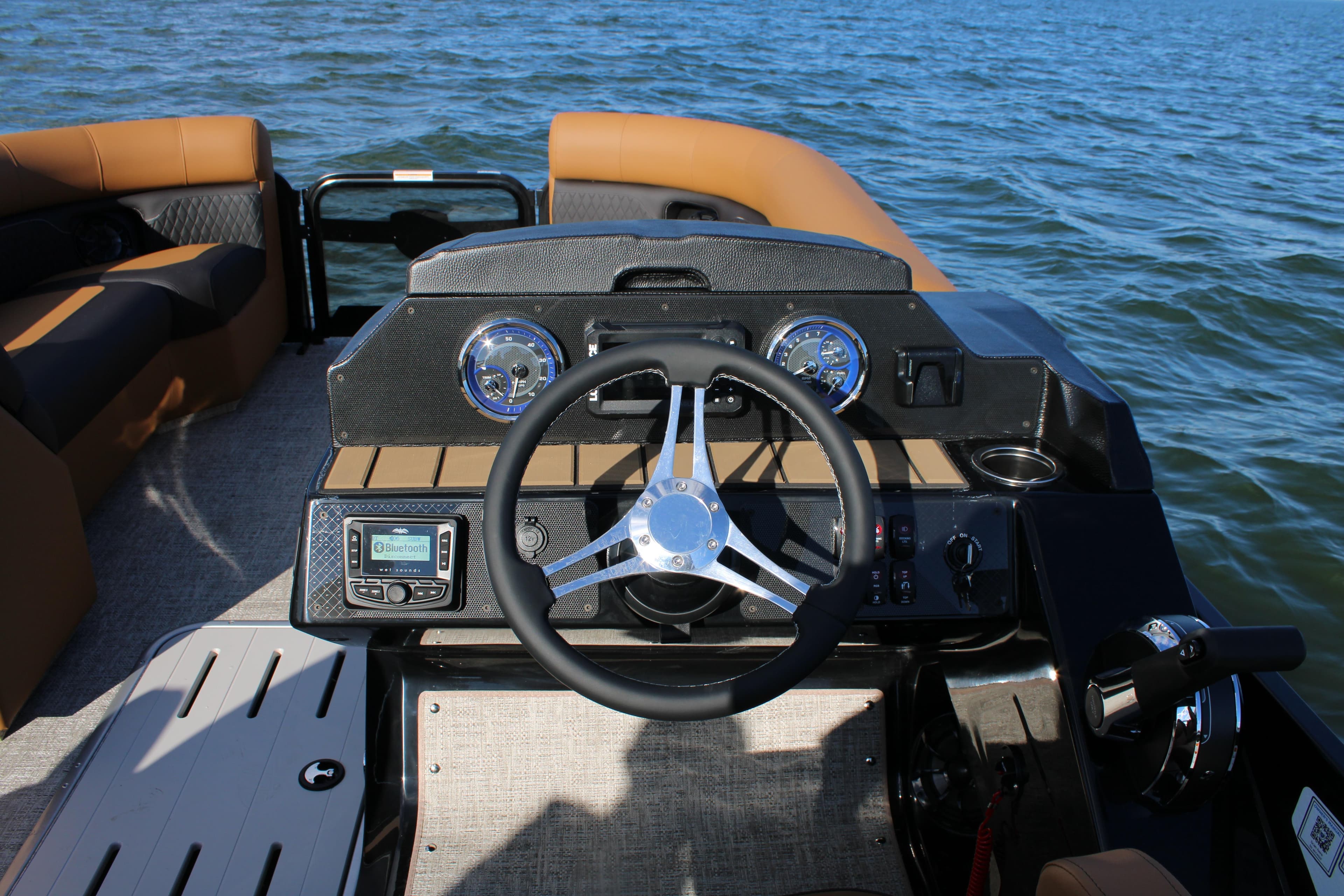 2026 Premier 230 SunSation RF boat dashboard with steering wheel on open water.