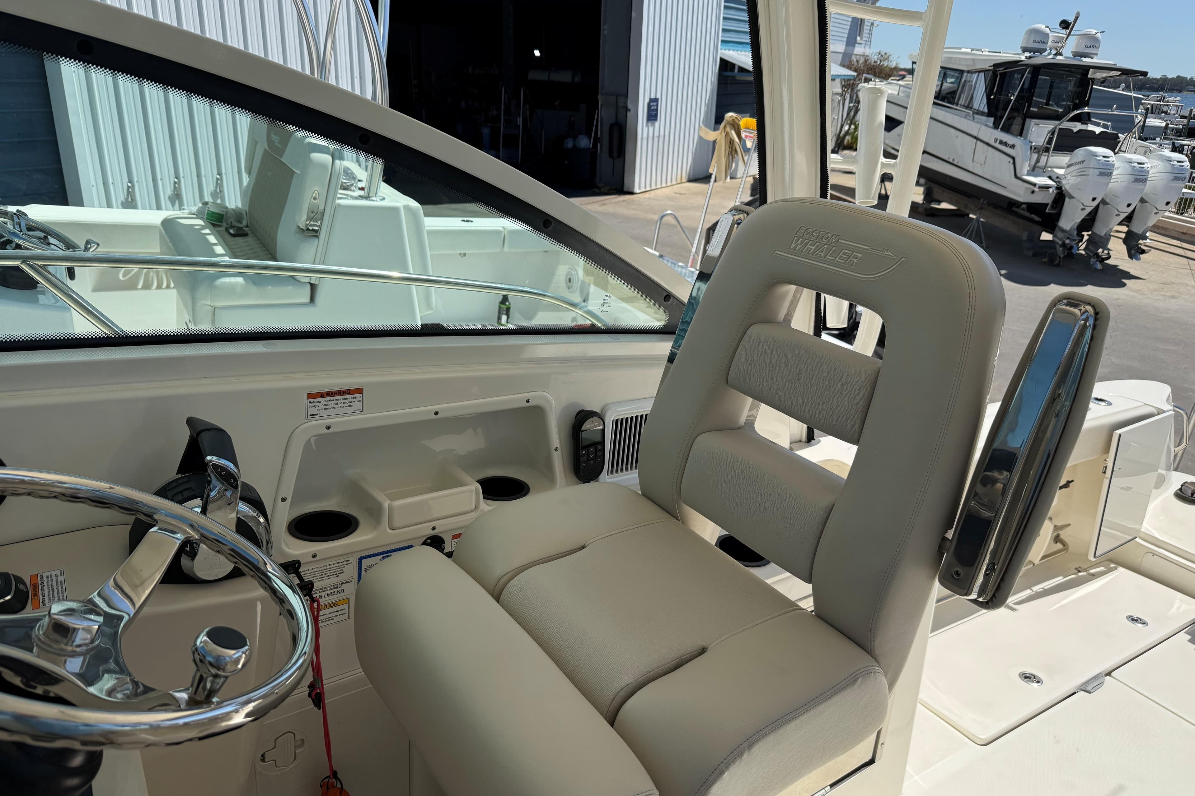 2019 Boston Whaler 315 Conquest helm with steering wheel and cushioned seat.