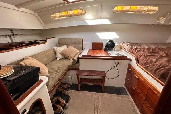 Cozy interior of 1988 Ocean Alan Wright sailboat with seating and wooden accents.