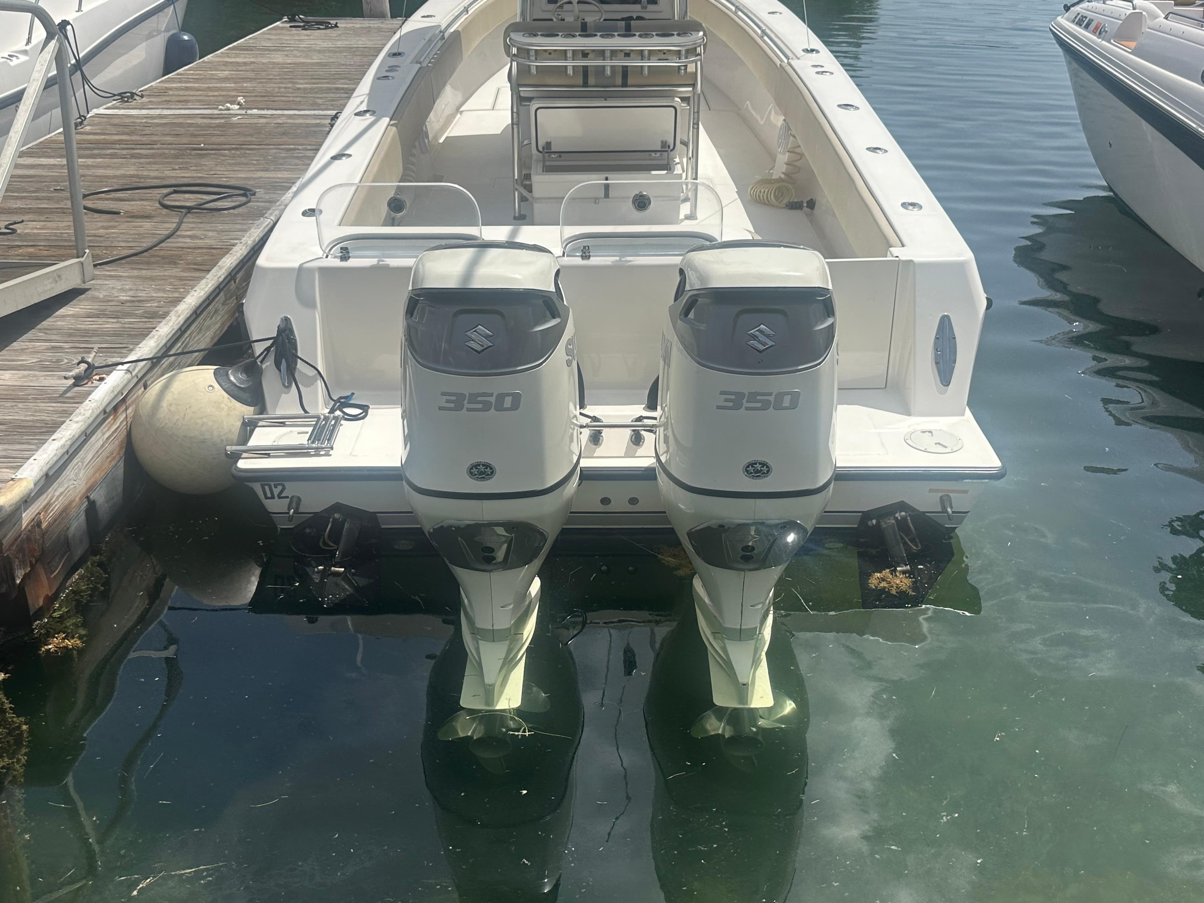 2008 Contender 36 Open boat with twin Suzuki 350 outboard engines docked at marina.