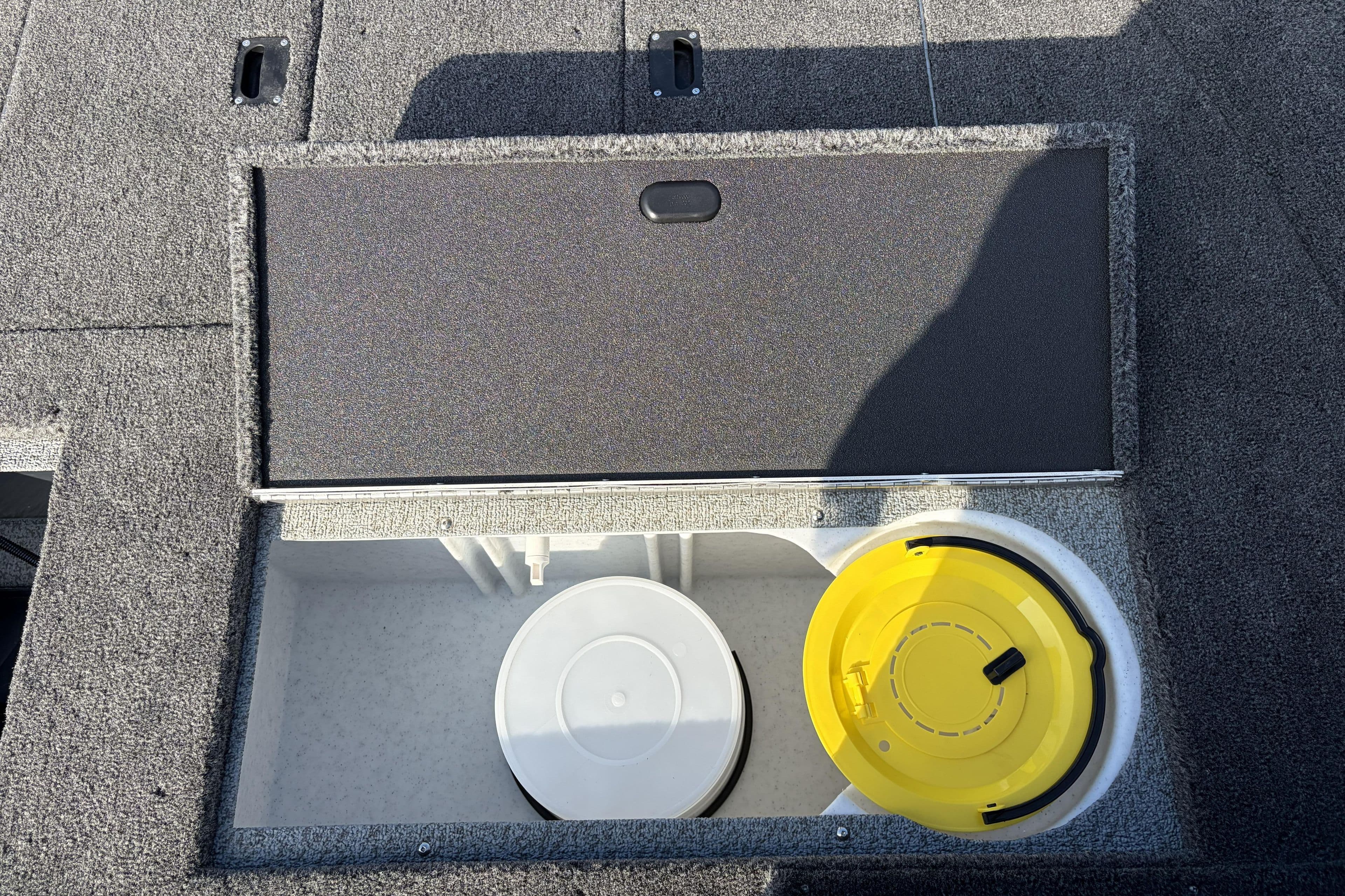 2026 Crestliner 1850 Kodiak SC boat storage compartment with yellow and white containers.