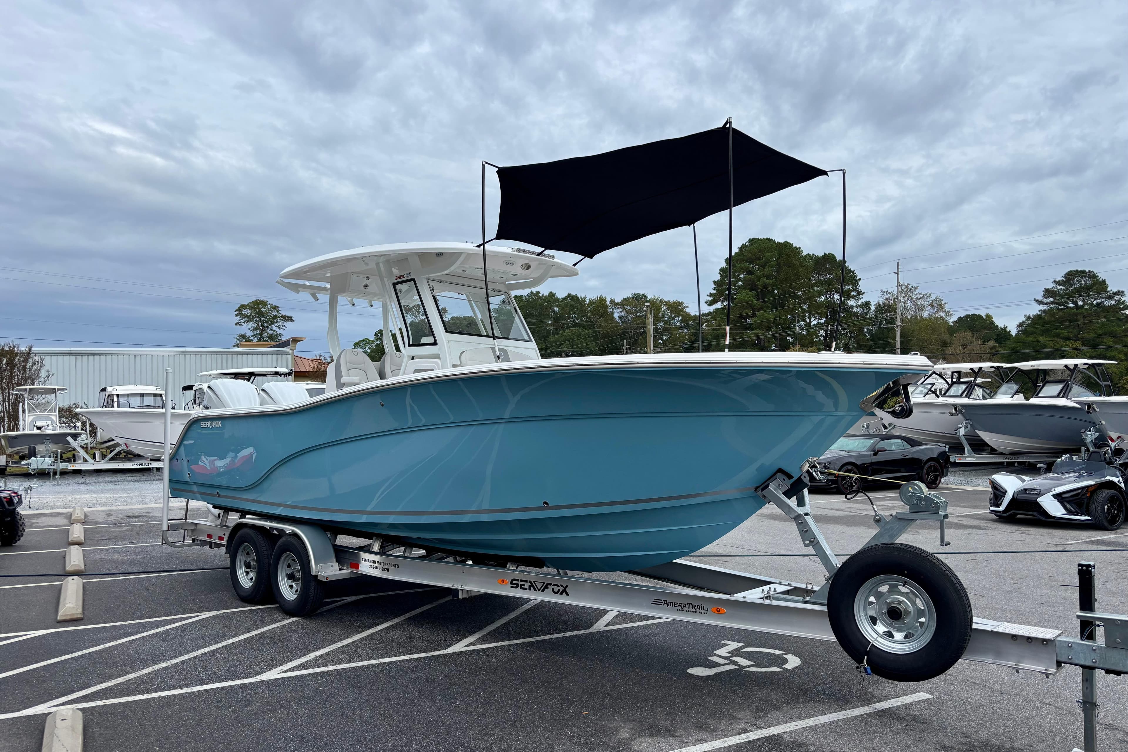 2026 Sea Fox 288 Commander boat on trailer, blue hull, parked outdoors.