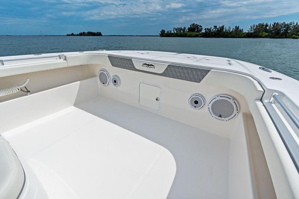 Invincible 46 Catamaran 2021, spacious deck view with speakers, on calm water.