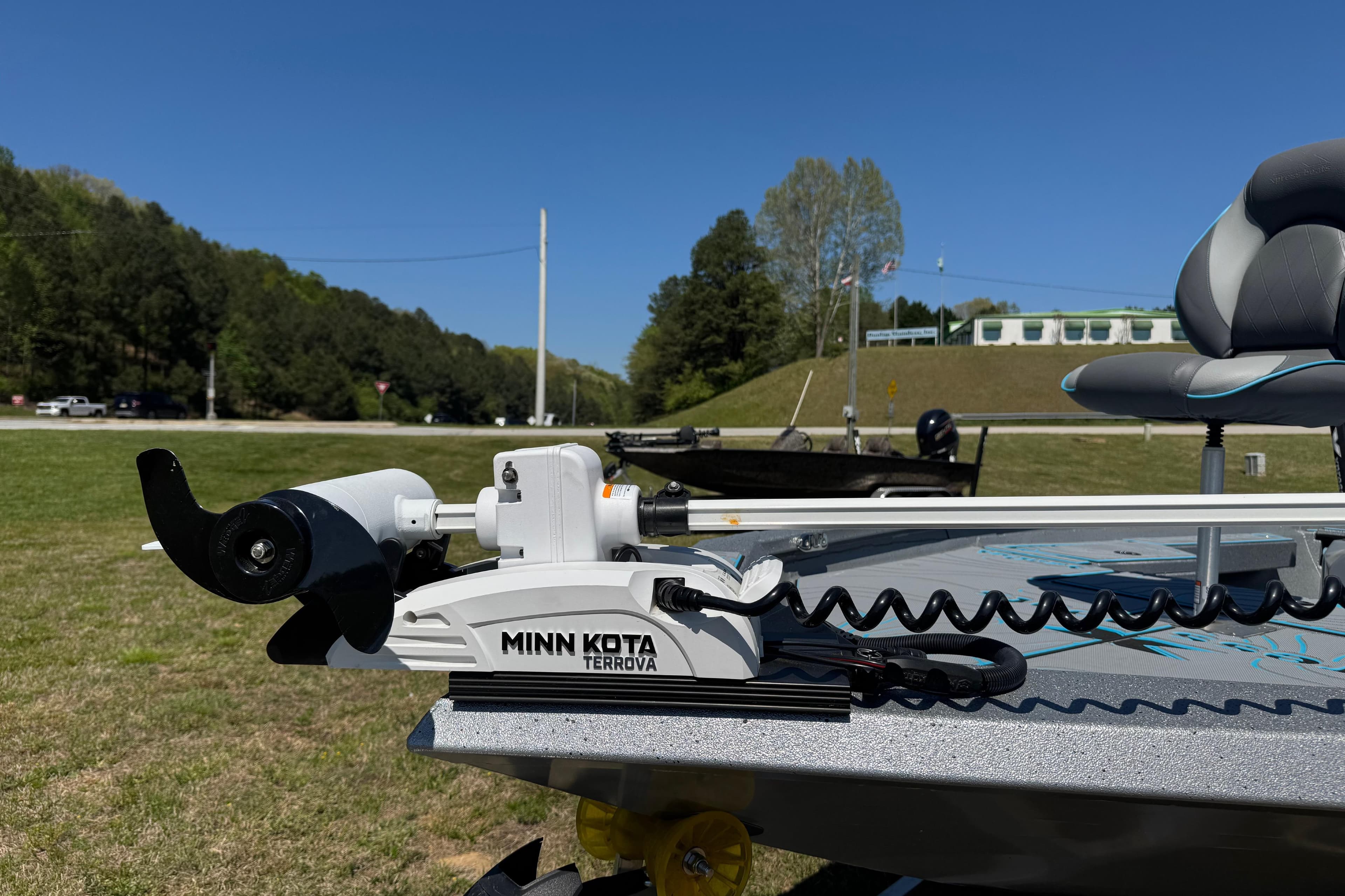 2025 Xpress H20B Bay boat with Minn Kota Terrova trolling motor on grassy area.
