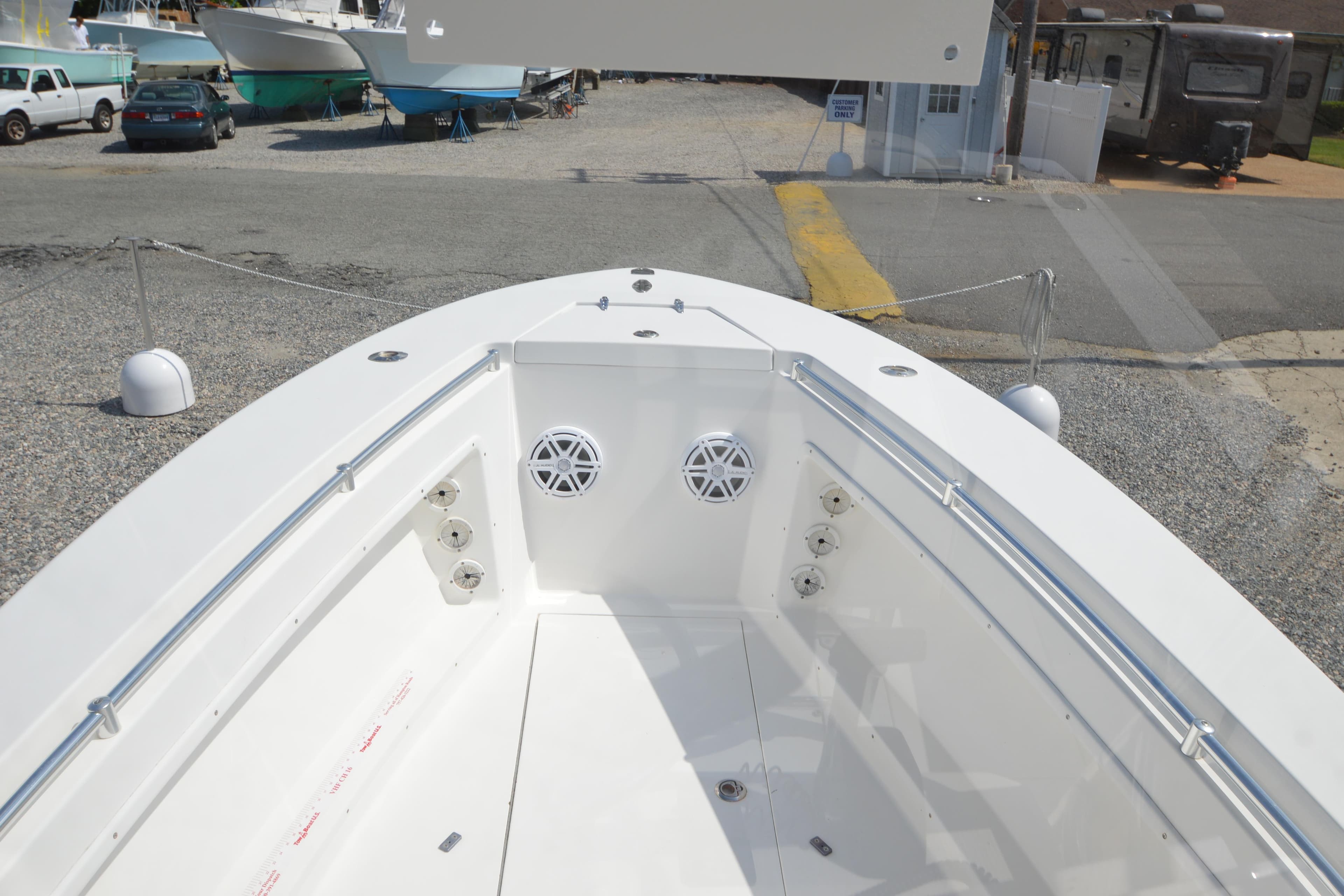 2008 Contender 23 Open boat interior with speakers and railing, parked on gravel.