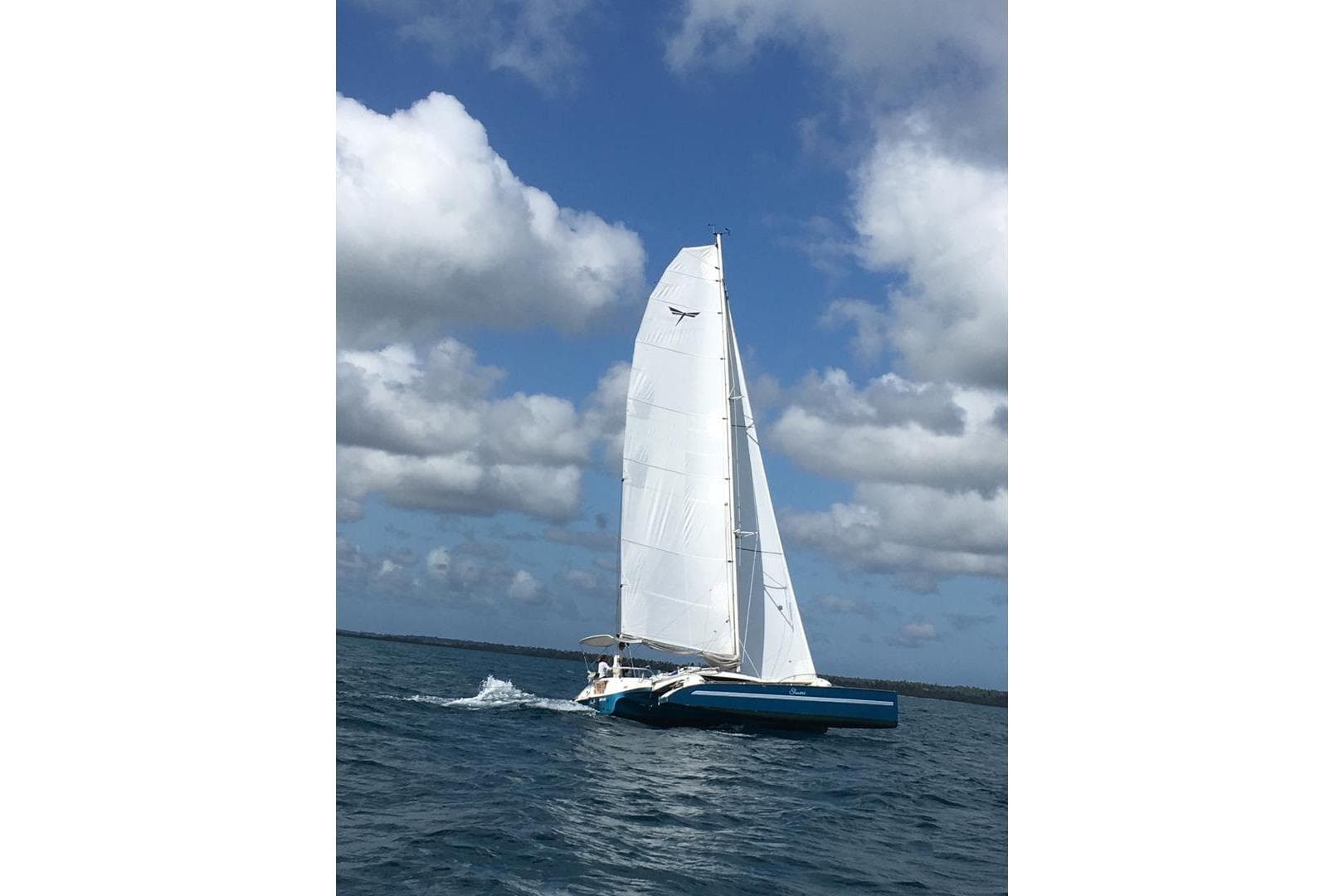 Sailing on open water, 2016 Dragonfly 32 Supreme trimaran under a cloudy sky.