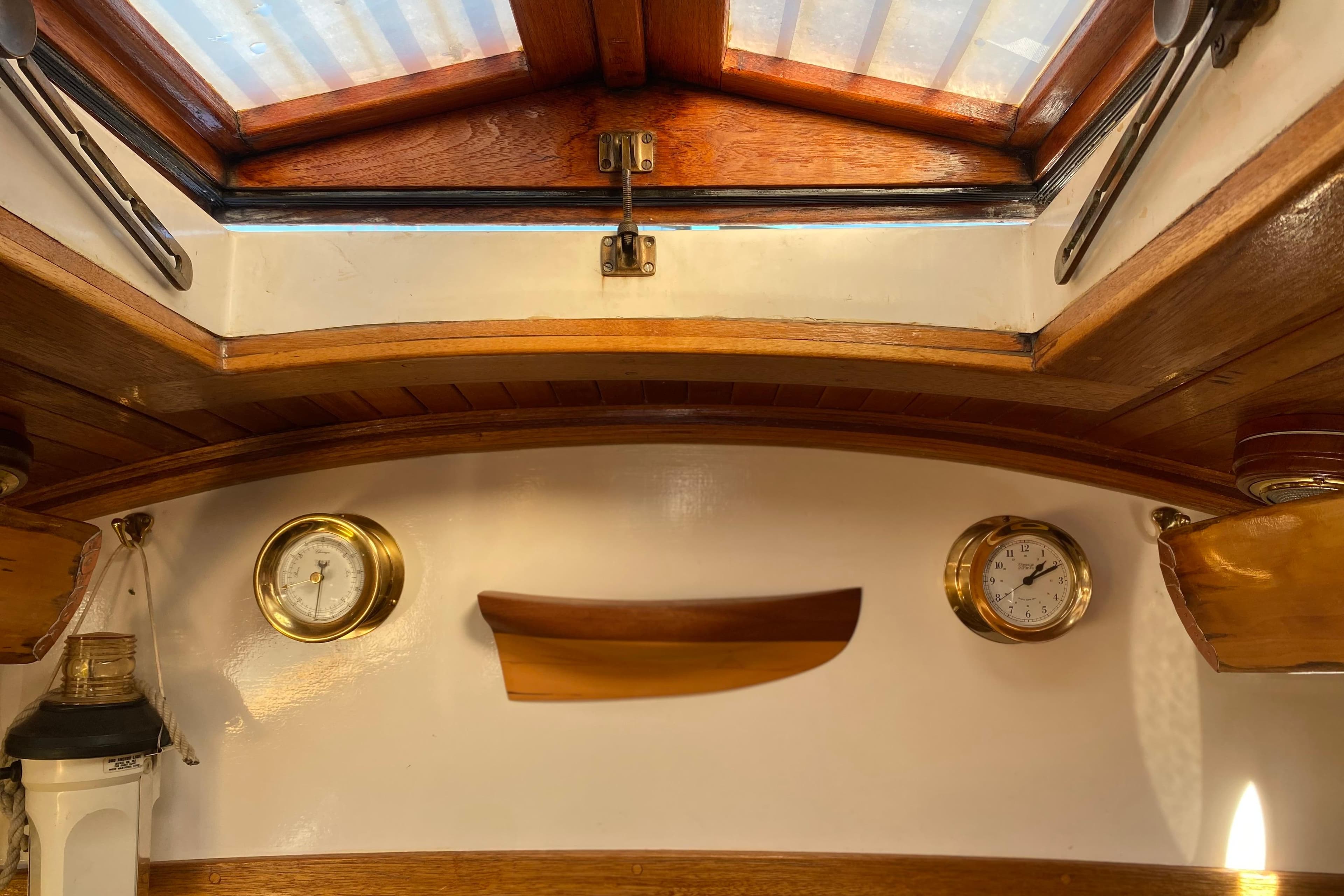 Interior of 1978 Bristol Channel Cutter 28 with wooden accents and nautical instruments.