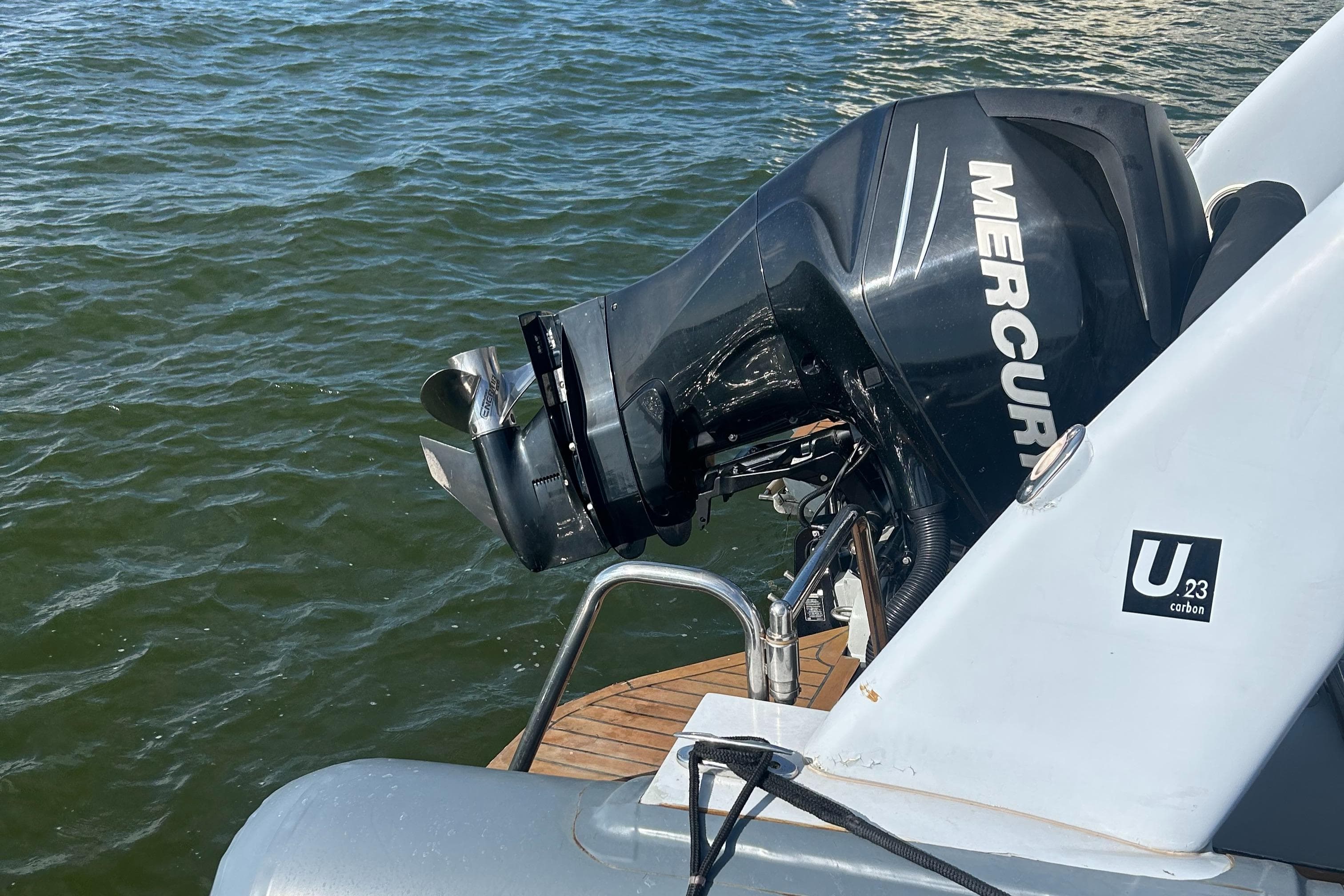 Outboard motor on 2008 RIB U-23 Carbon Hull boat, floating on water.