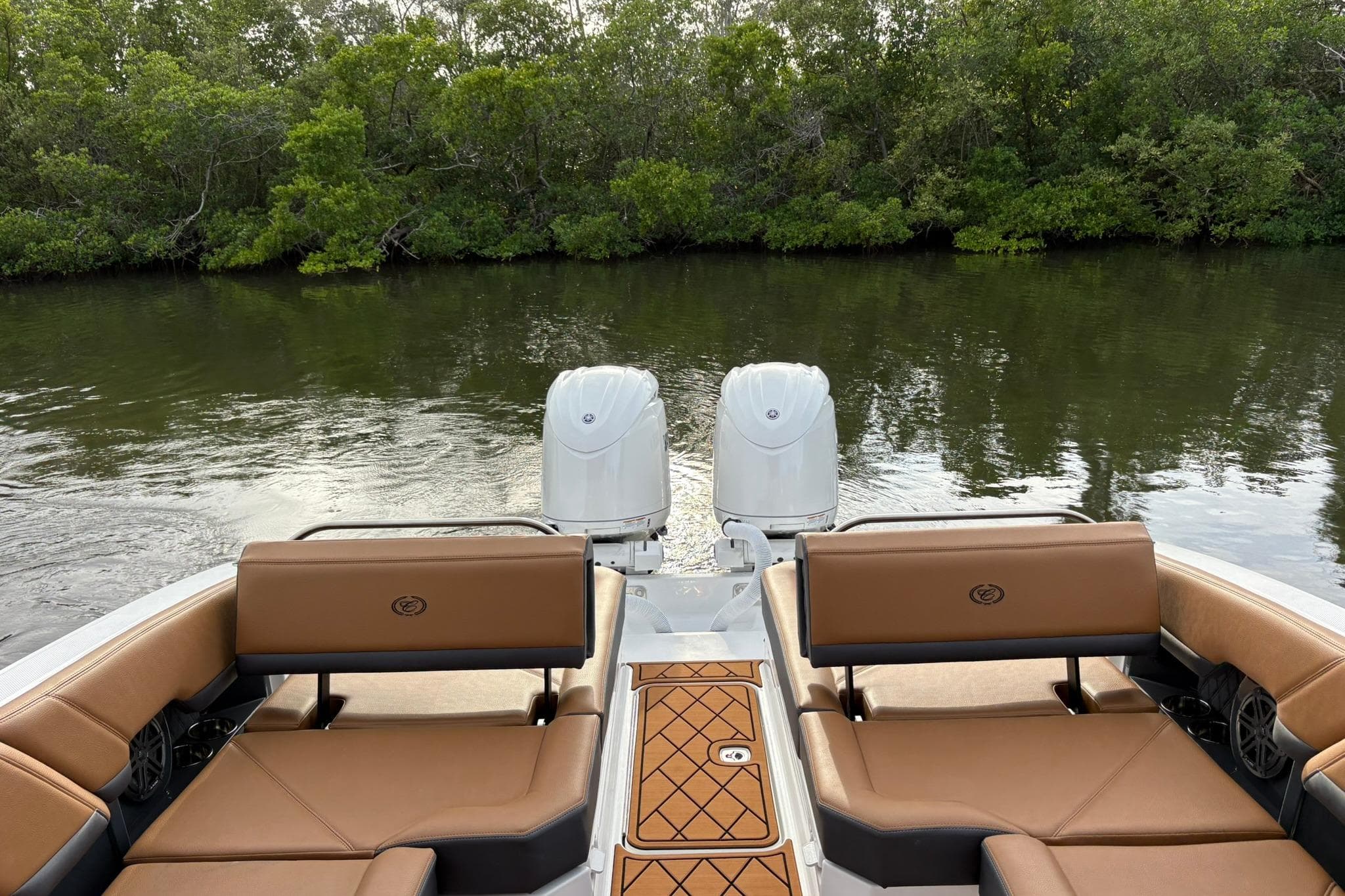 2026 Cobalt R8 Outboard boat with dual engines, brown seating, and scenic water backdrop.