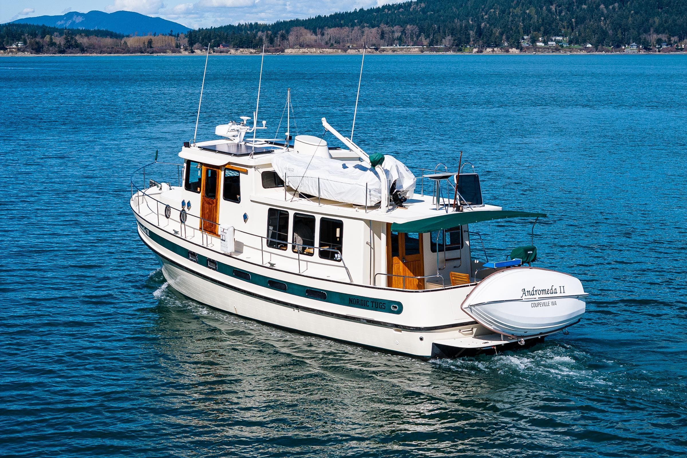 Nordic Tug 42, 1997 model, cruising on a scenic blue lake.