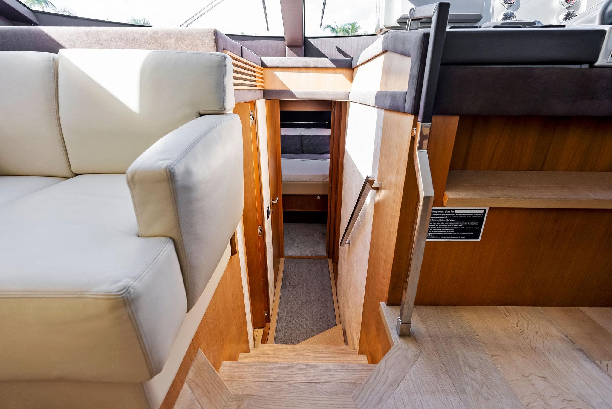 Interior view of 2013 Absolute 55 FLY yacht with wooden stairs and seating area.