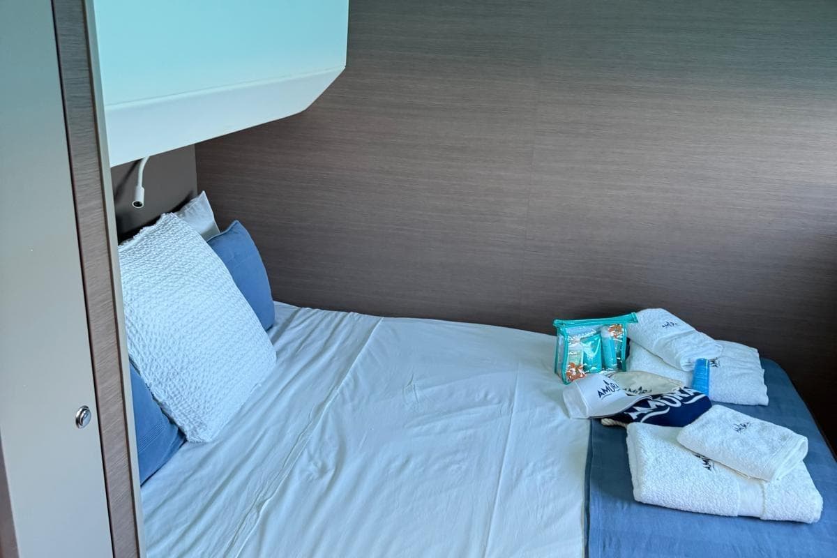 Cozy cabin bed in 2021 Bali 5.4 Open Space yacht with towels and toiletries.