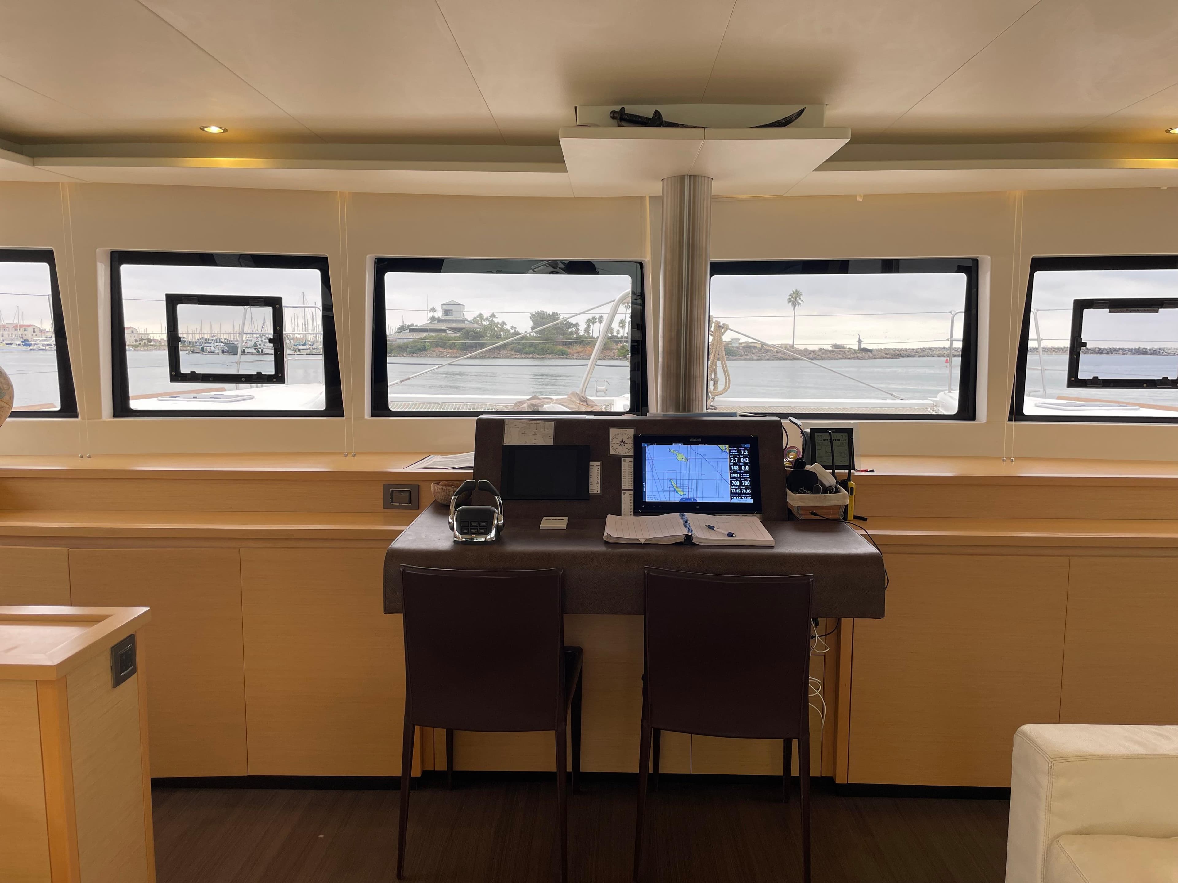 Interior view of 2019 Lagoon 620 yacht's navigation station with panoramic windows.