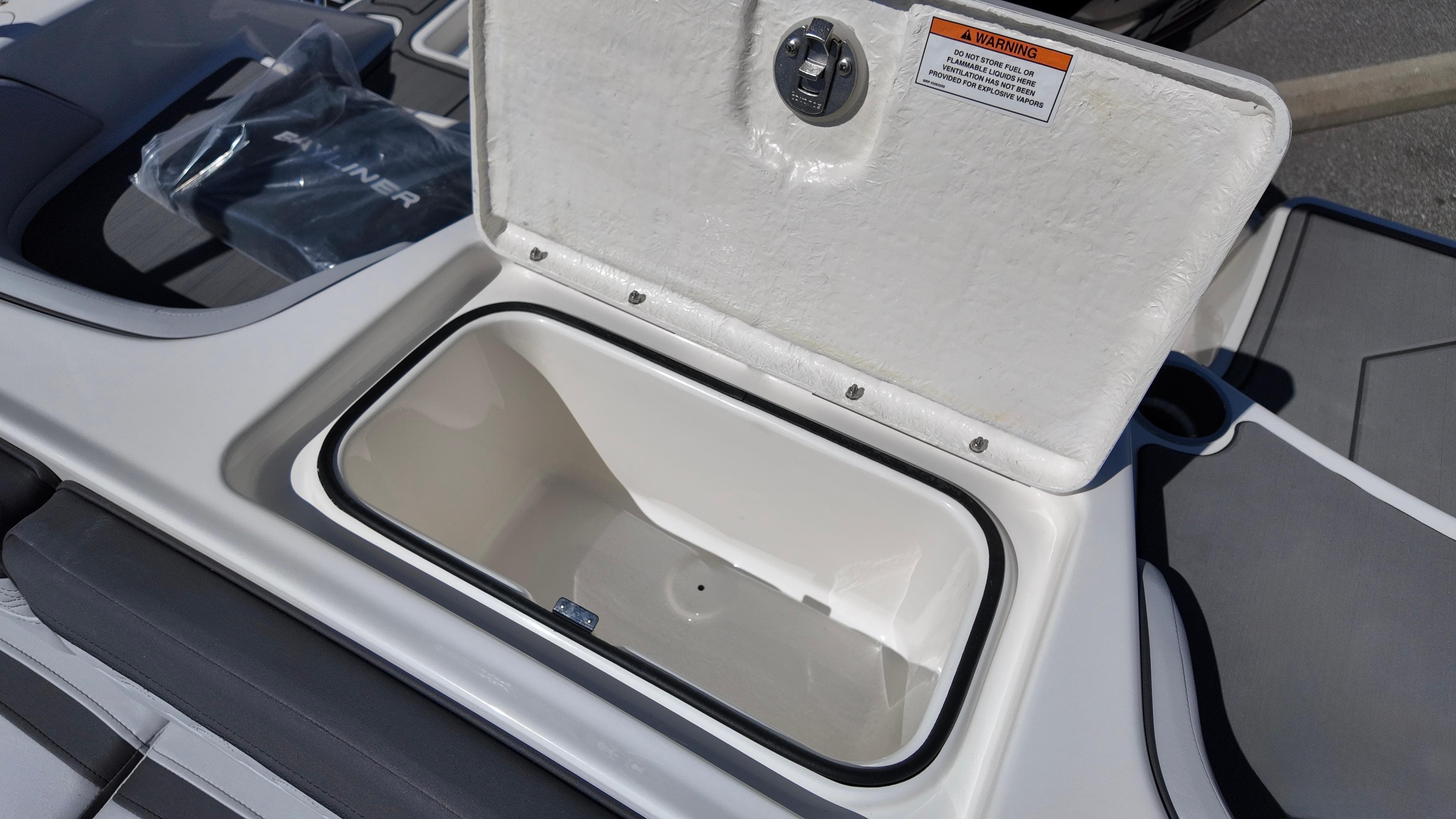 Open storage compartment on 2025 Bayliner M17 boat, showcasing interior space.