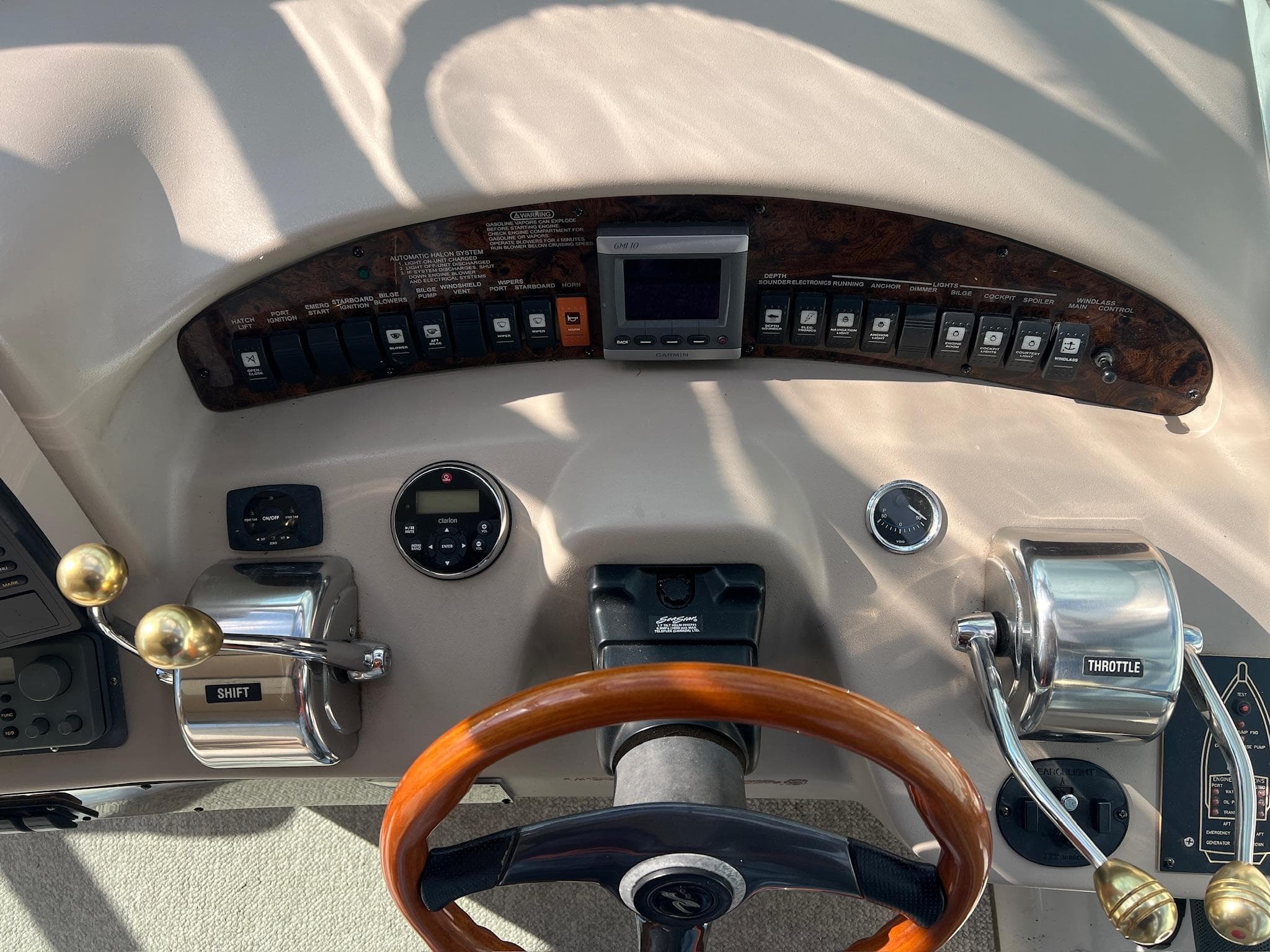 Control panel of a 2001 Sea Ray 340 Sundancer boat with steering wheel and throttle controls.