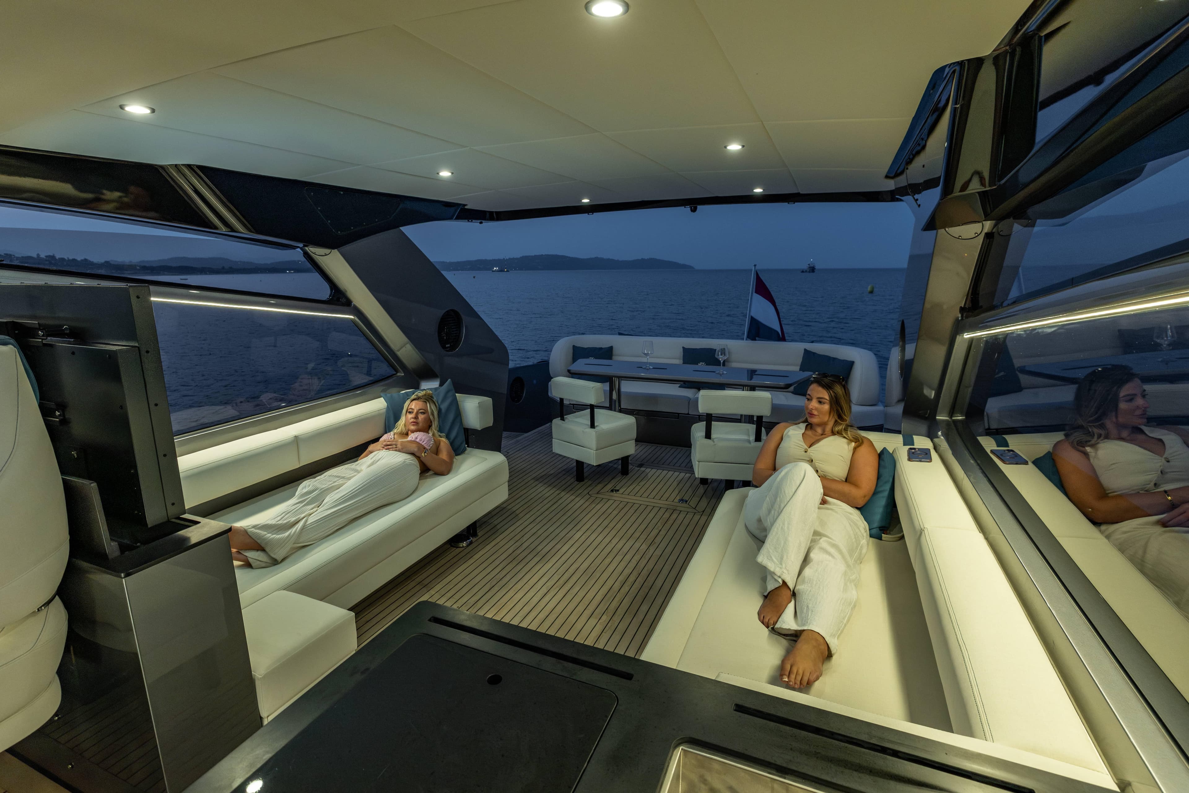 Luxurious interior of 2025 Steeler Bronson 65 yacht with people relaxing at sea.