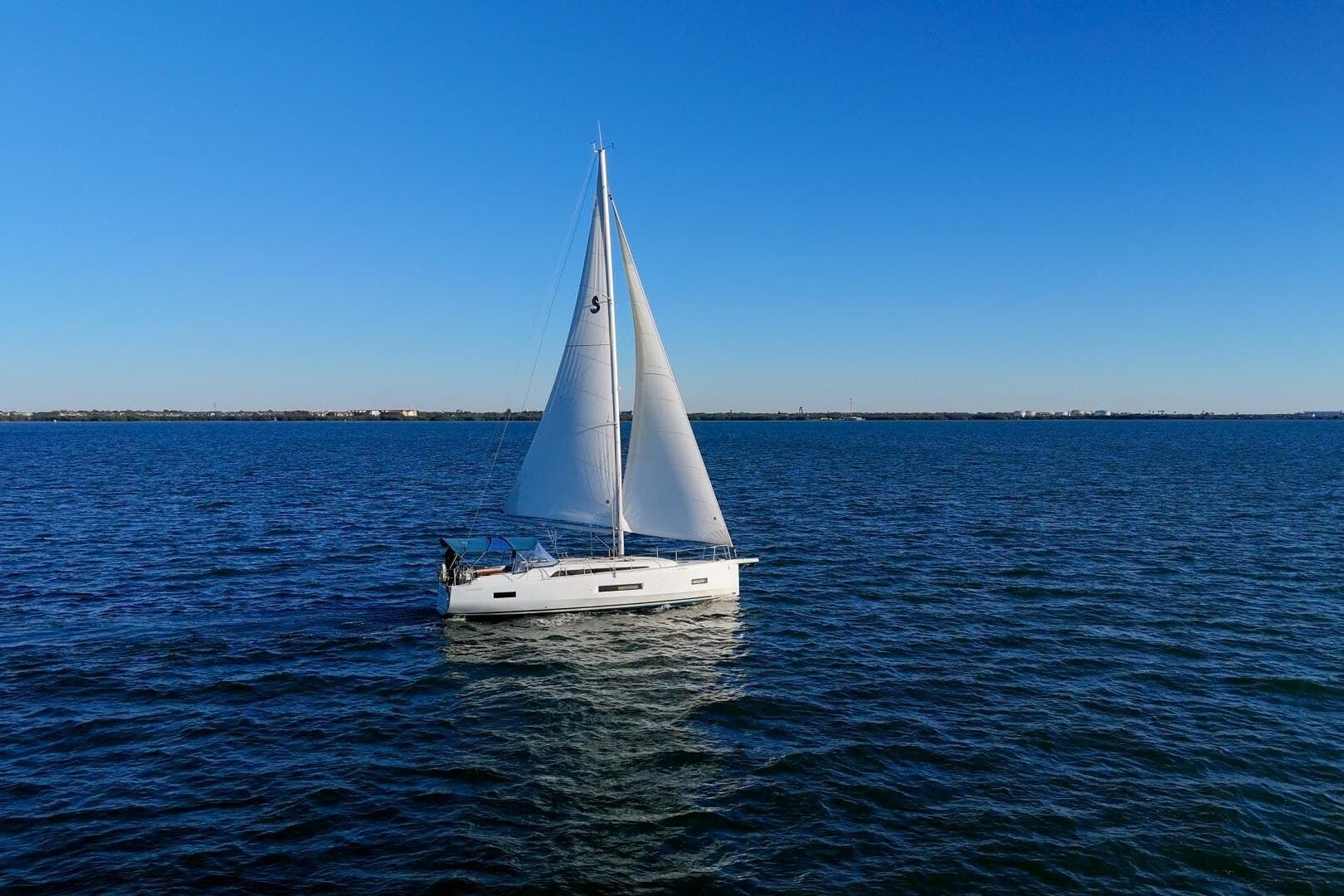 2022 Beneteau Oceanis 40.1 sailing on open water under clear blue sky.
