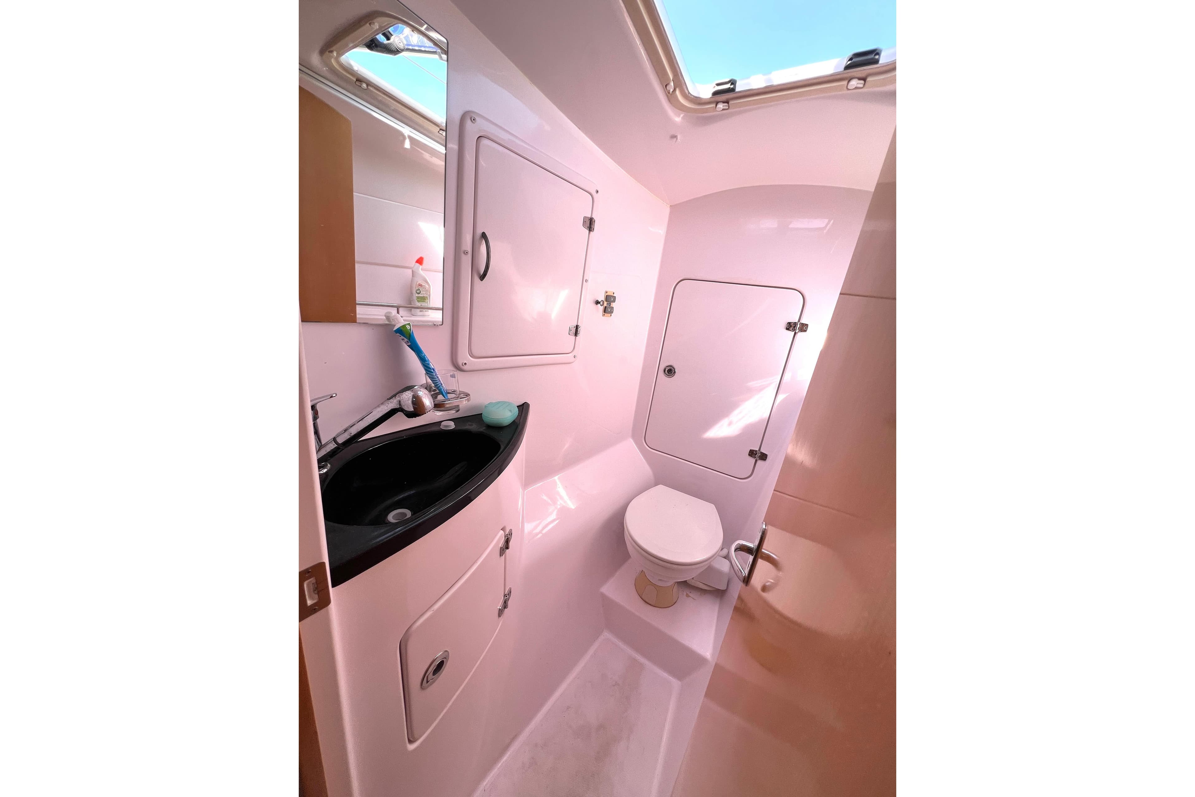 Seawind 1250 2016 yacht bathroom with sink, toilet, and storage compartments.