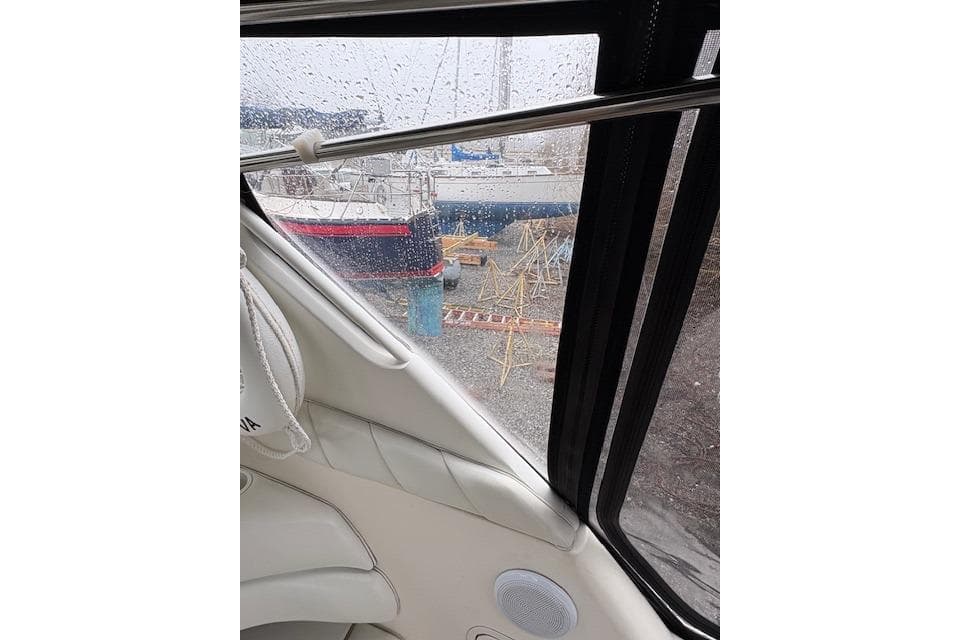 1998 Sea Ray Sundancer 330 interior view with rainy window and docked boats outside.