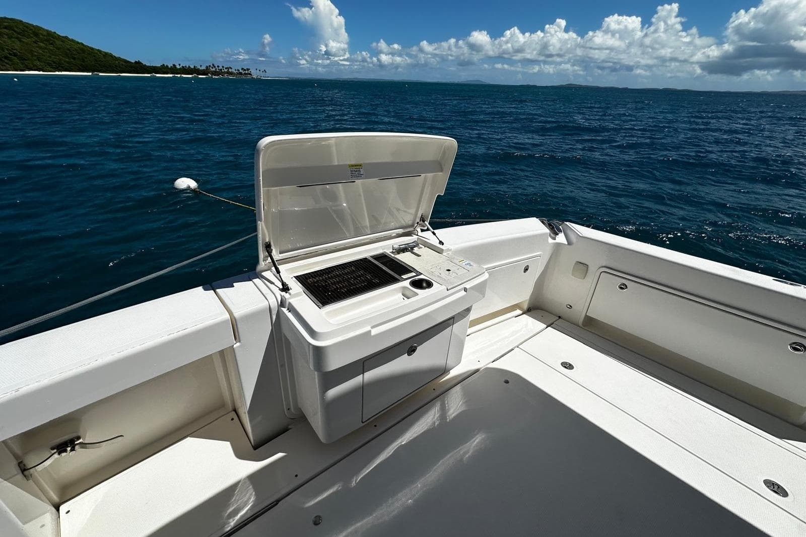 Riviera 43 Flybridge 2012 yacht deck with open grill, ocean view, and clear skies.