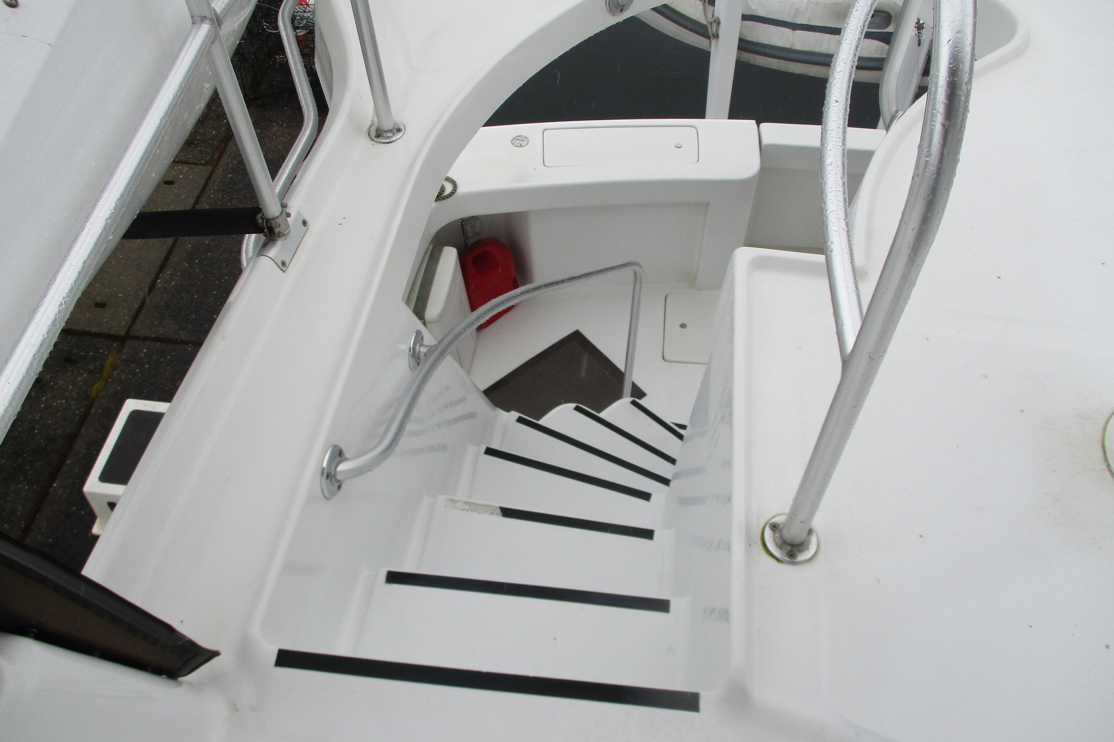Staircase on 1997 Mainship 350 Trawler with metal railings and white steps.