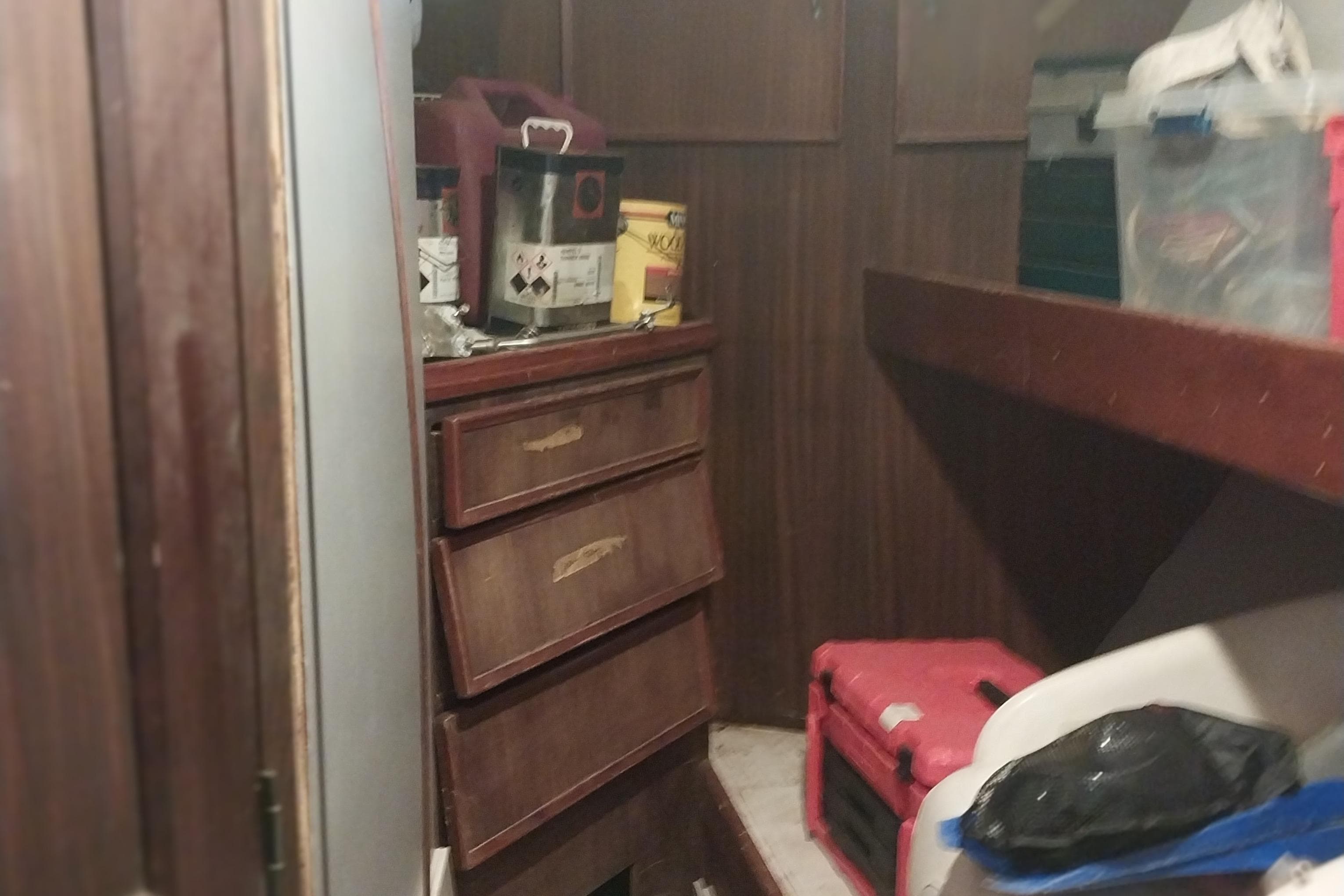 Interior of 1982 Hatteras 61 Motor Yacht with wooden cabinets and storage items.